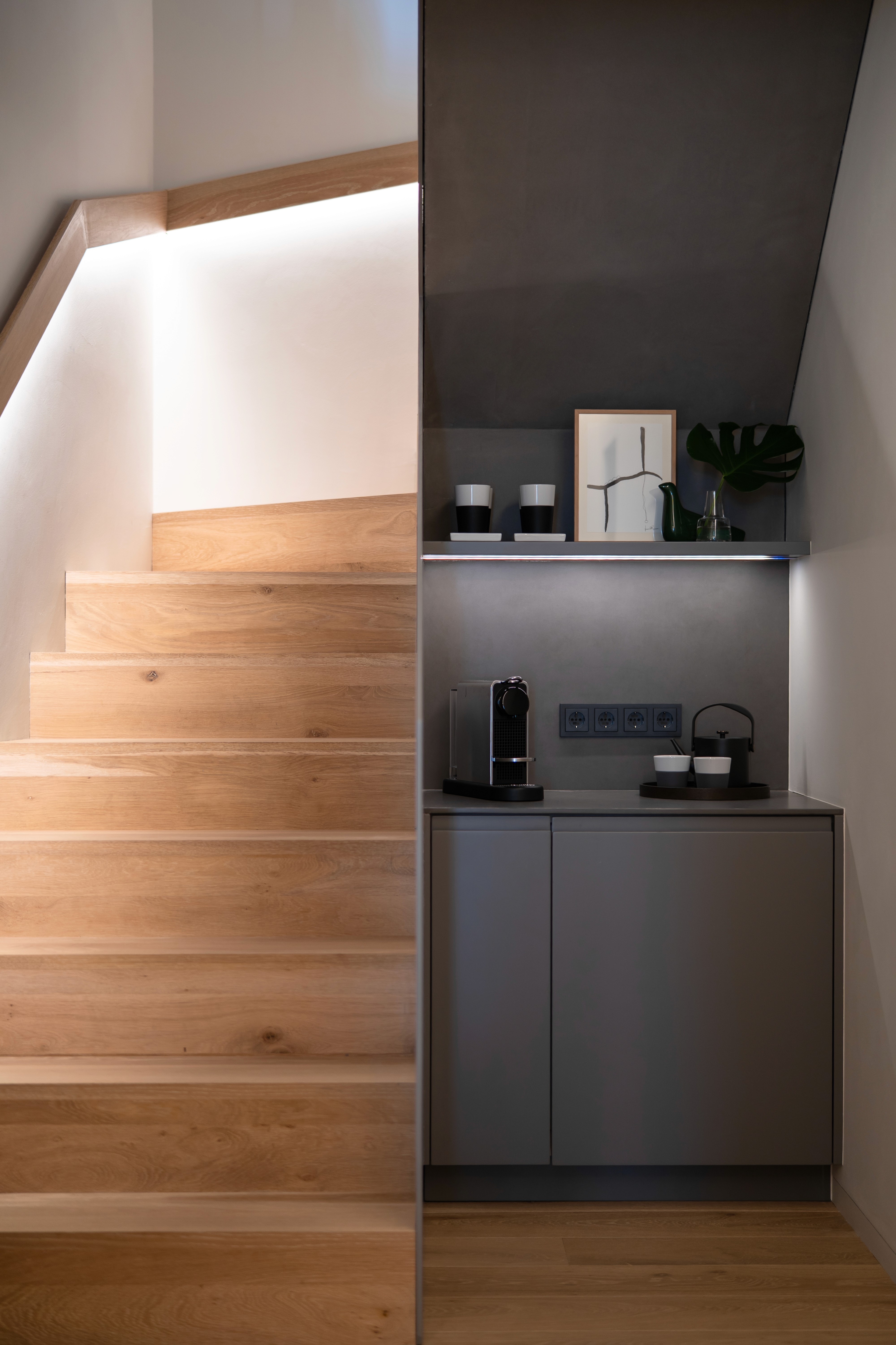 Pequeña zona de café bajo escaleras de madera