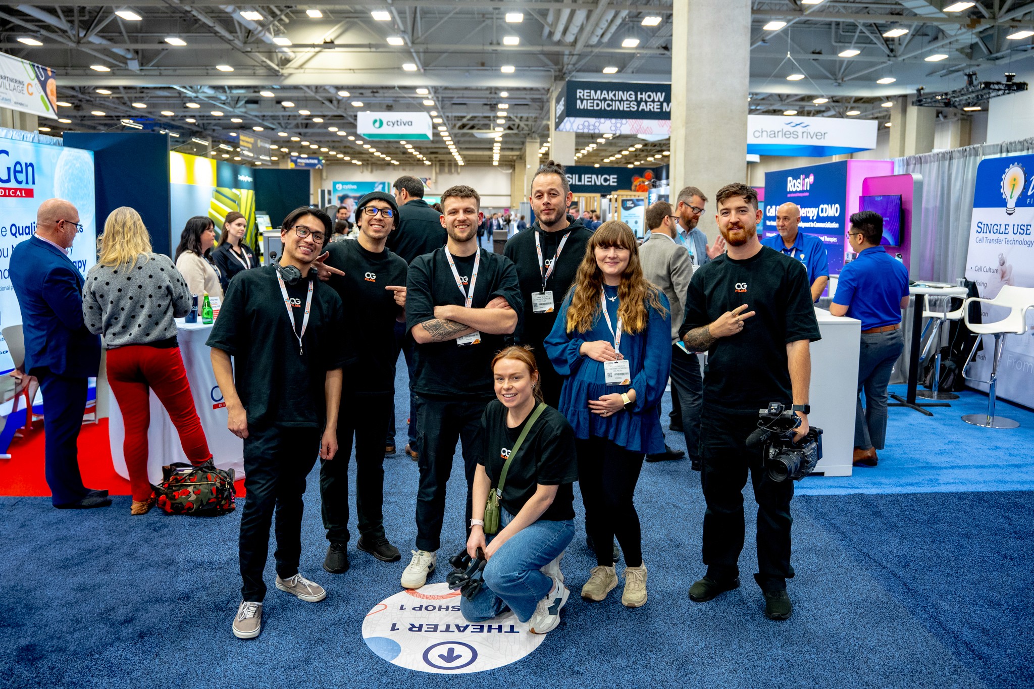 Black and white photo of two people looking at a computer screen with papers on wall