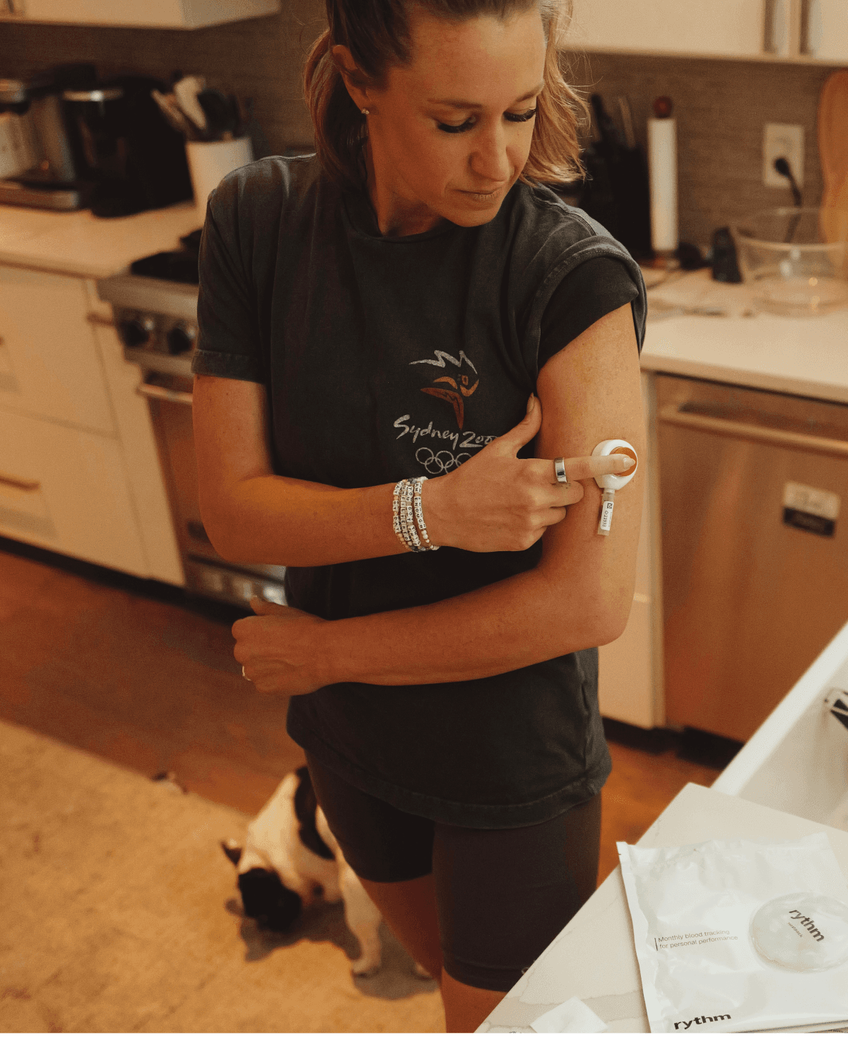 Katie collecting a blood sample from her upper arm at home.