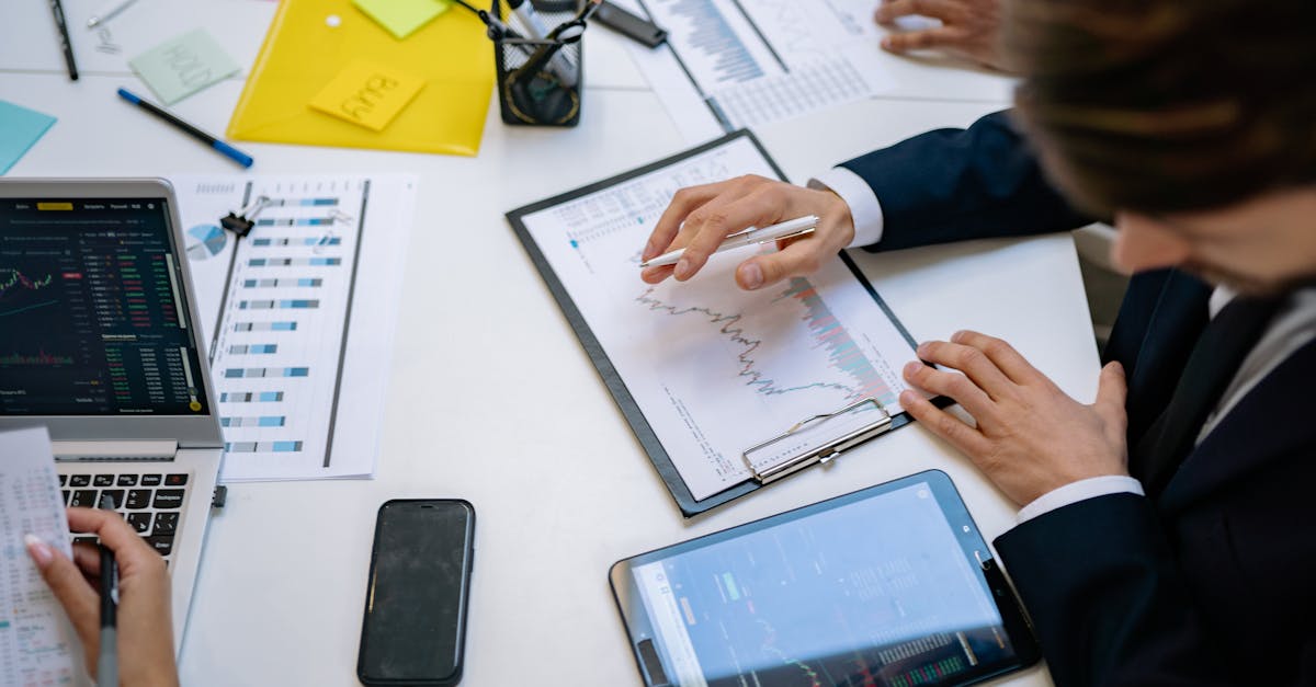 Team reviewing financial charts and digital data on tablets in an office setting.