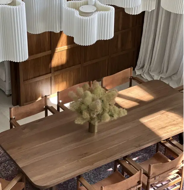 Vista superior de comedor de madera con arreglo floral neutro para estudios de interiorismo que buscan transmitir calidez, textura y equilibrio natural.