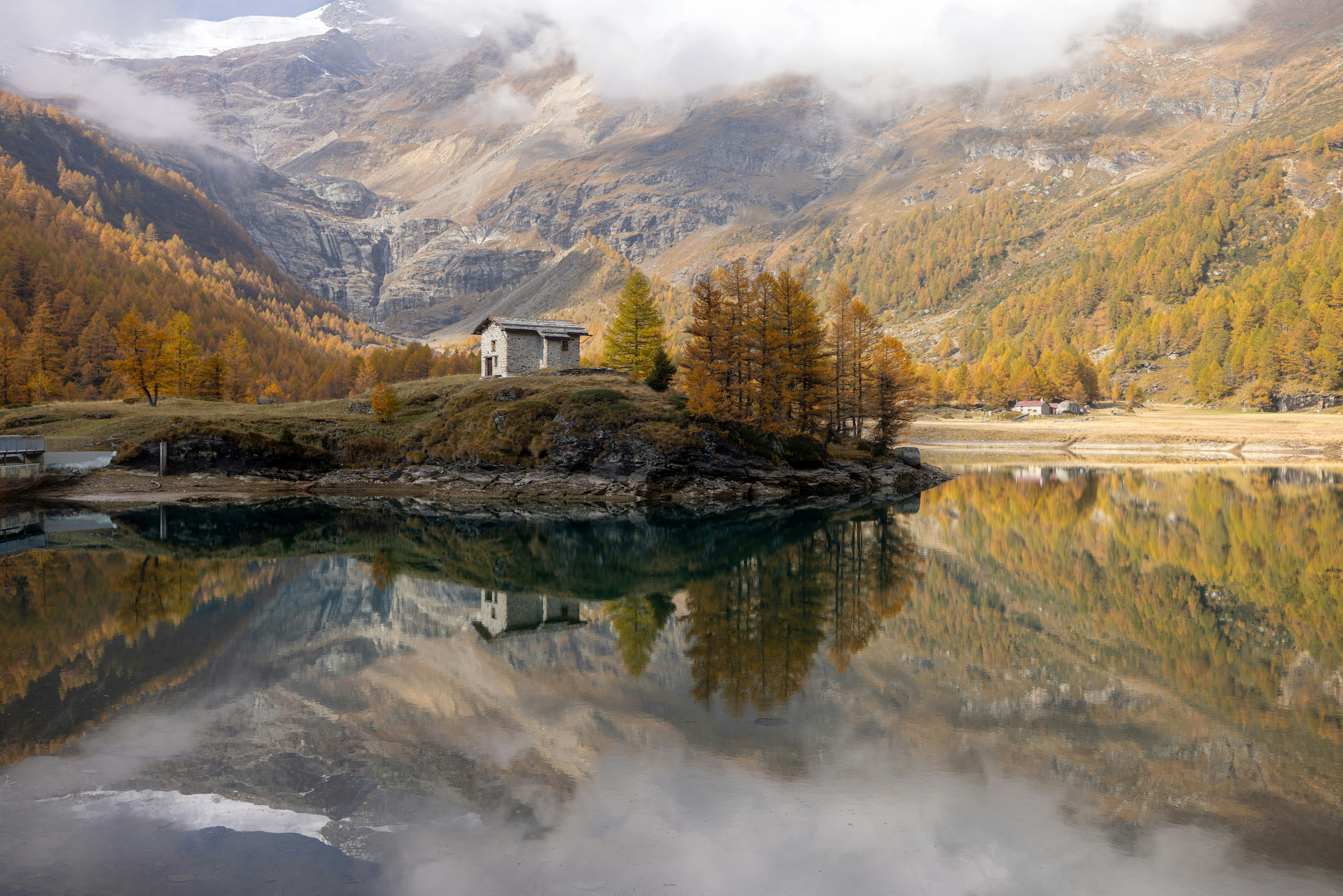 Small house on a hill by a lake with reflections