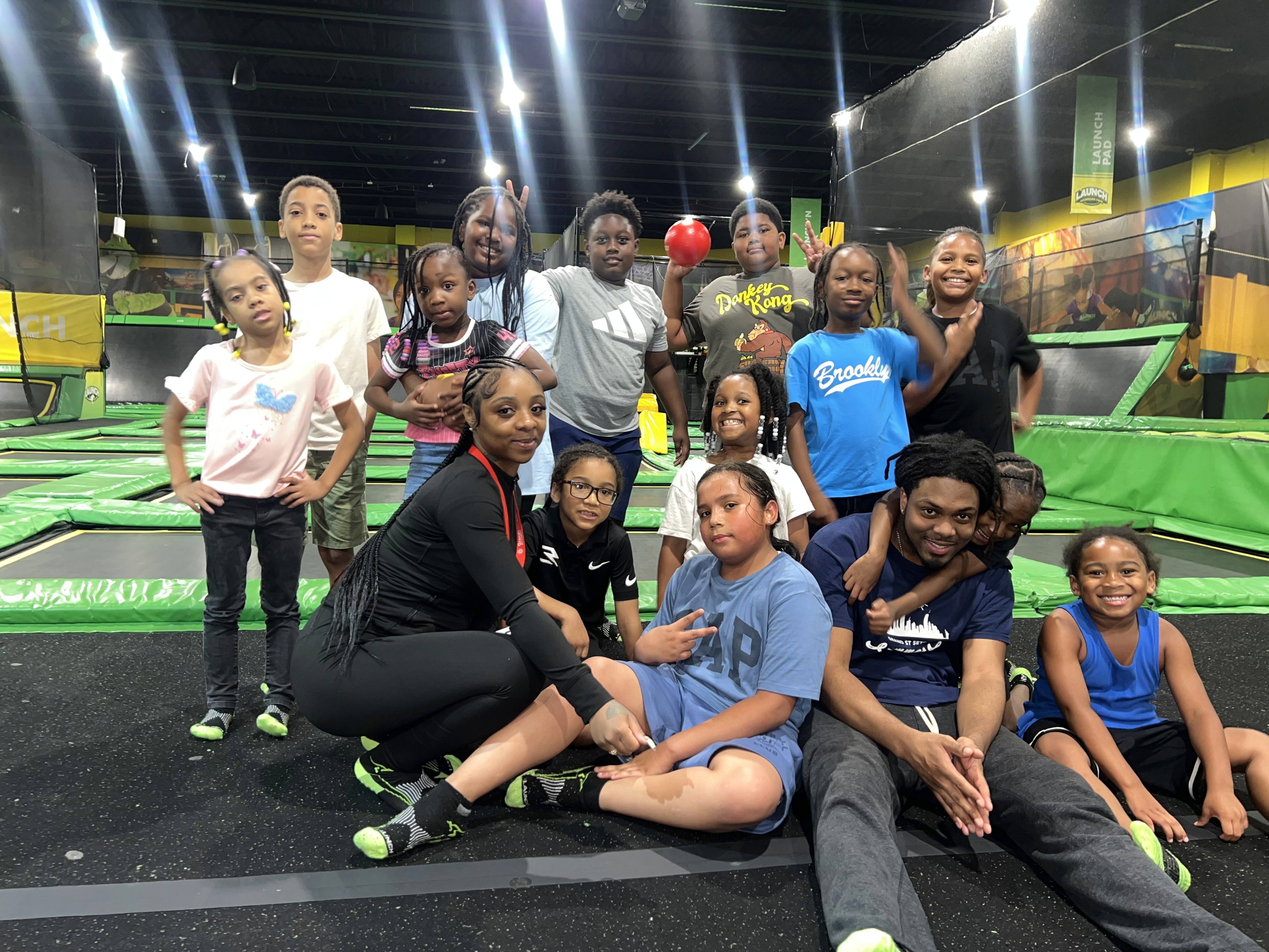 A girl's softball team poses showing off their uniforms and gear.
