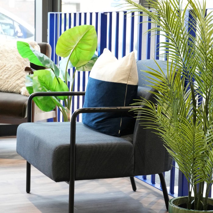 Indoor seating area with pot plants, chairs with cushions