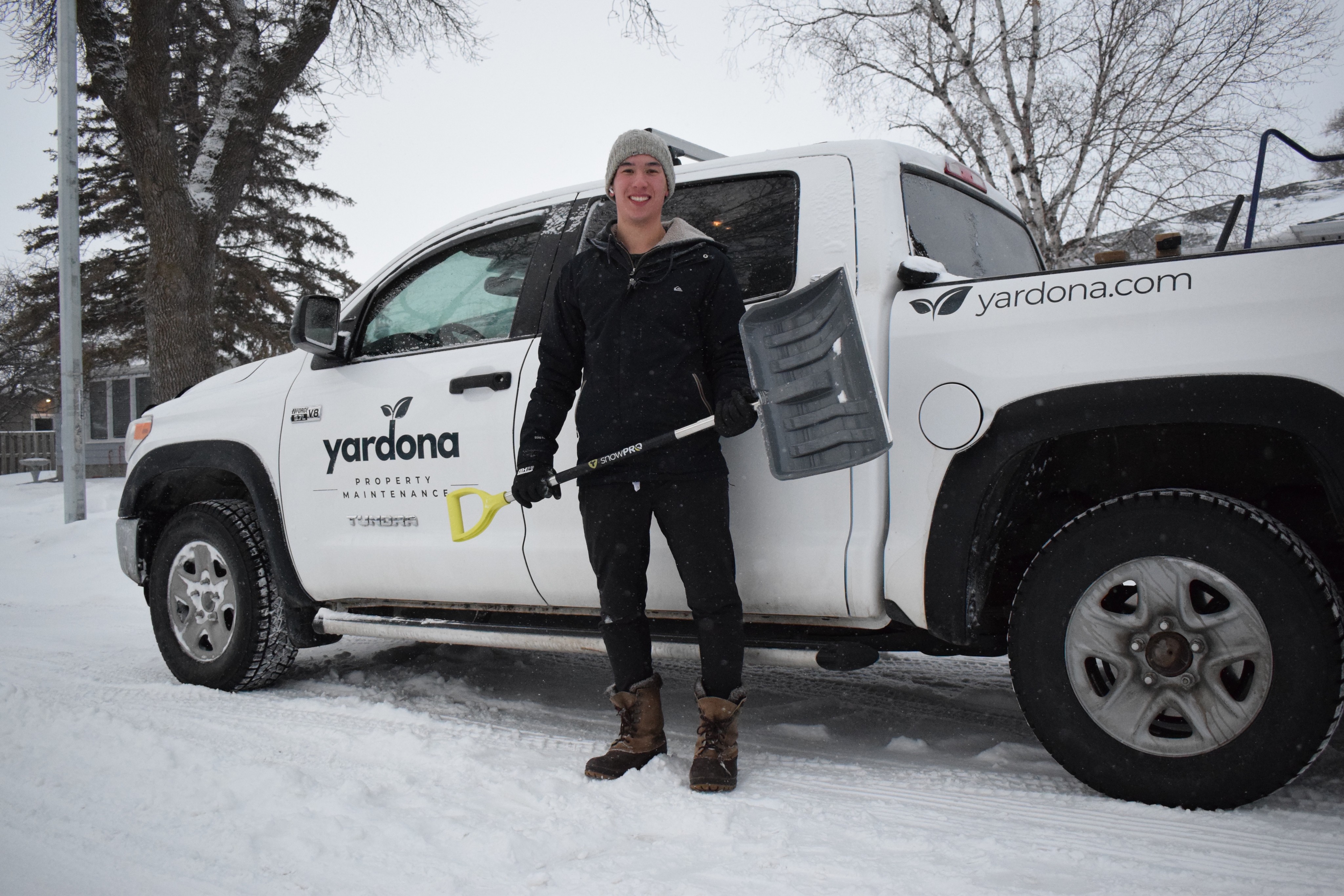 Standing in front of a truck in River Heights with a snow shovel