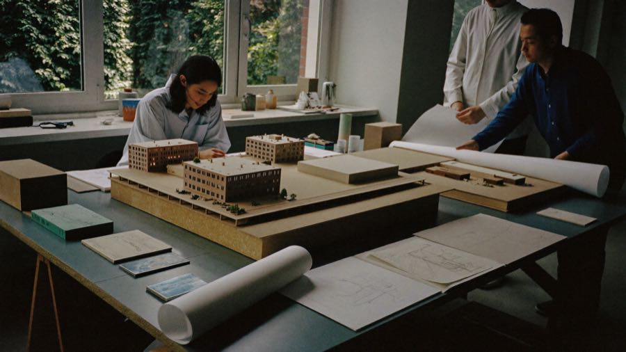 Architects reviewing building models and drawings in a studio, TERAMOK architecture marketing