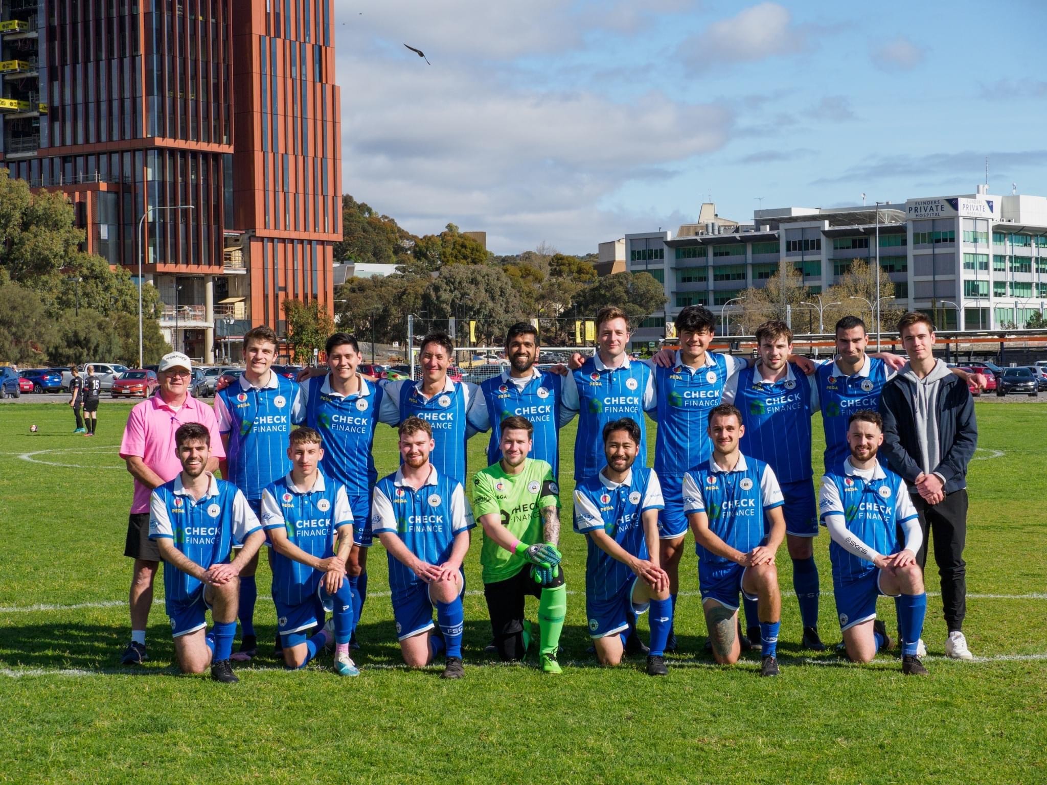 People playing soccer on a rooftop court surrounded by city buildings