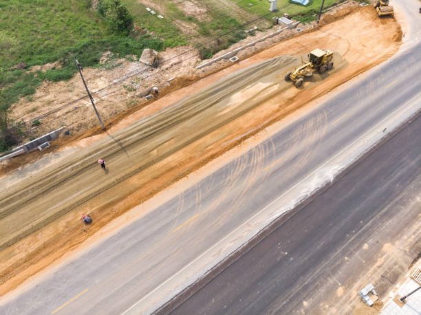 Aerial view of roadway grading and base preparation work in Kansas City with heavy equipment compacting subgrade