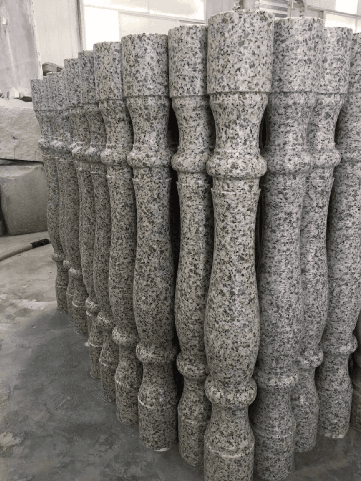 Finished stone balusters crafted by the Vertical 4 Pillars Baluster Cutting Machine, demonstrating the machine's capability to produce uniform and detailed architectural elements.