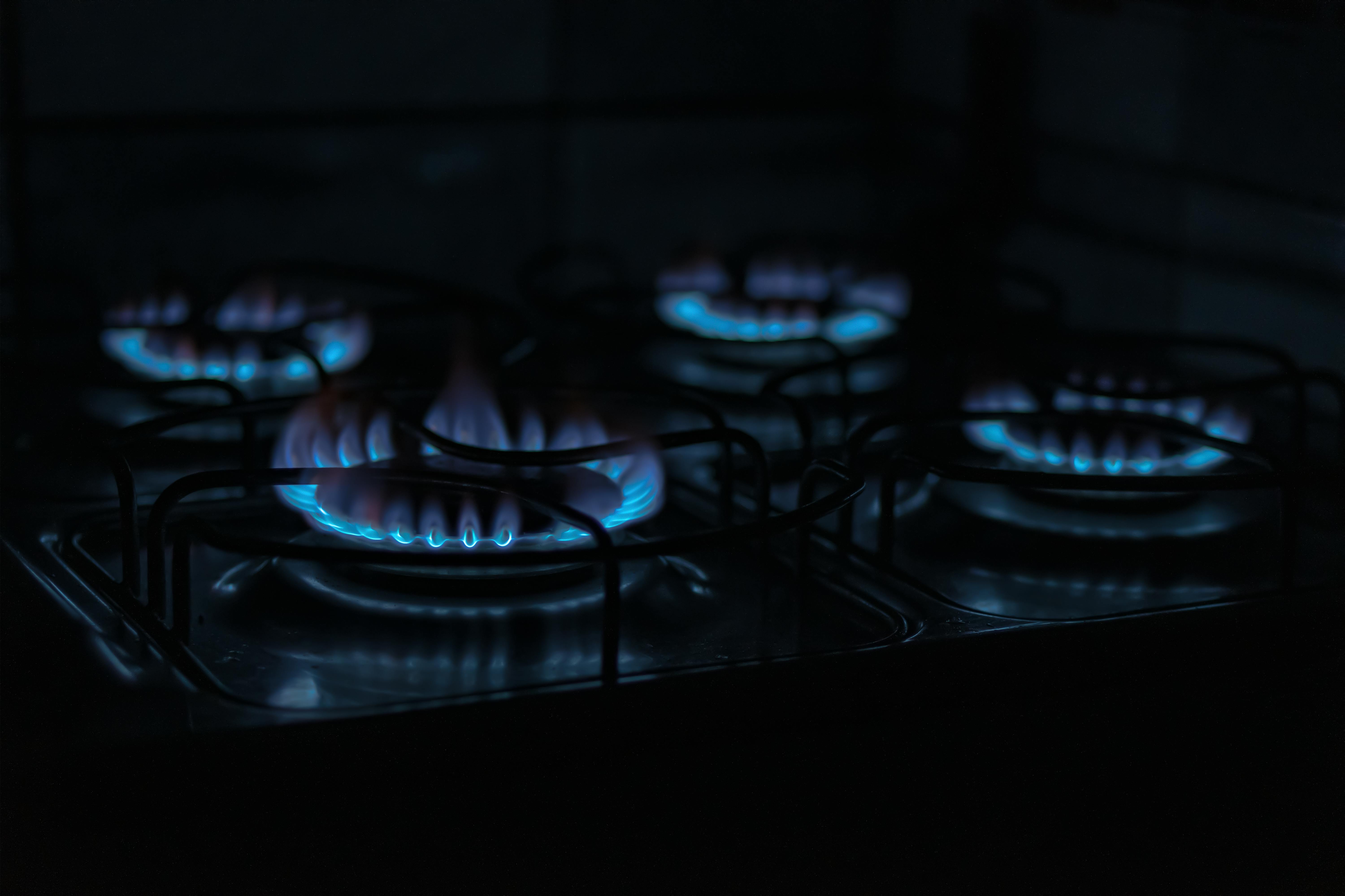 A close up of a gas stove with a blue flame