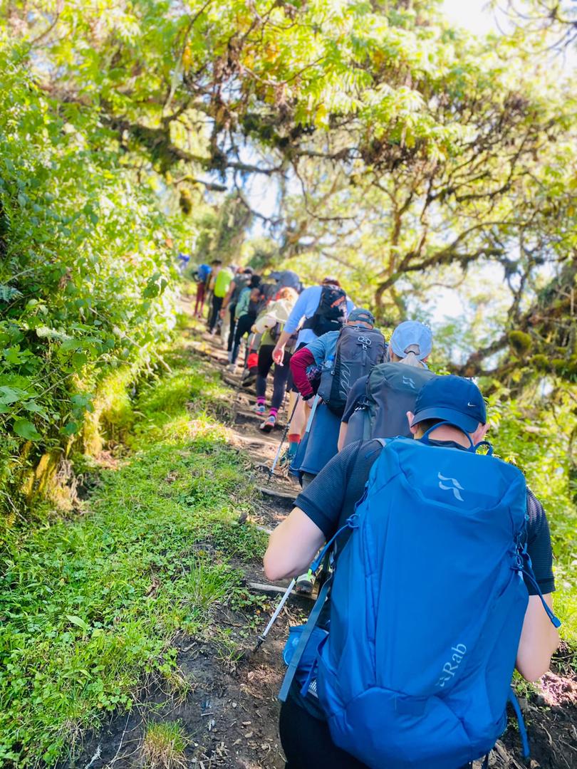 Layered desert mountains near AlUla, painted in red, beige, and orange tones under evening light.