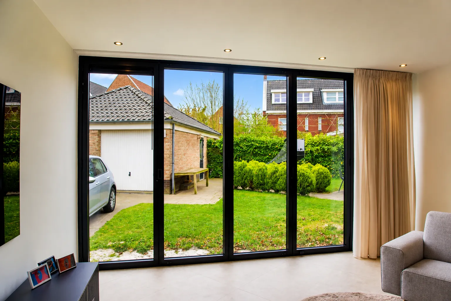 Moderne aanbouw met zwarte kunststof schuifpui aan de Patmos in Zoetermeer