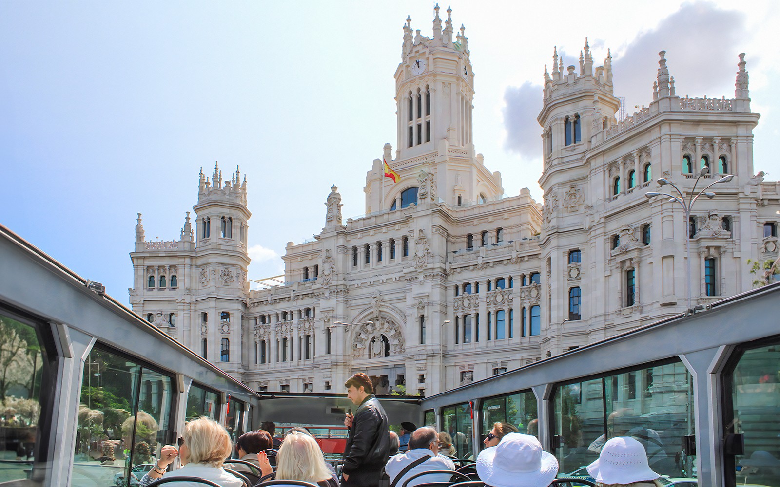 Åpen busstur som passerer Palacio de Cibeles i Madrid.