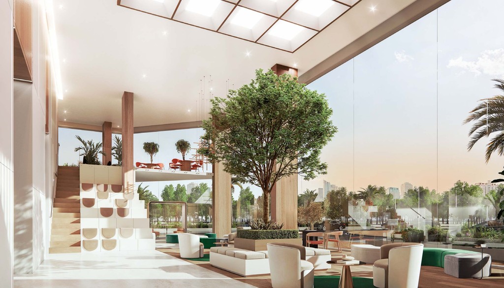 A modern lobby featuring a tree and stylish chairs, creating a welcoming atmosphere for visitors.