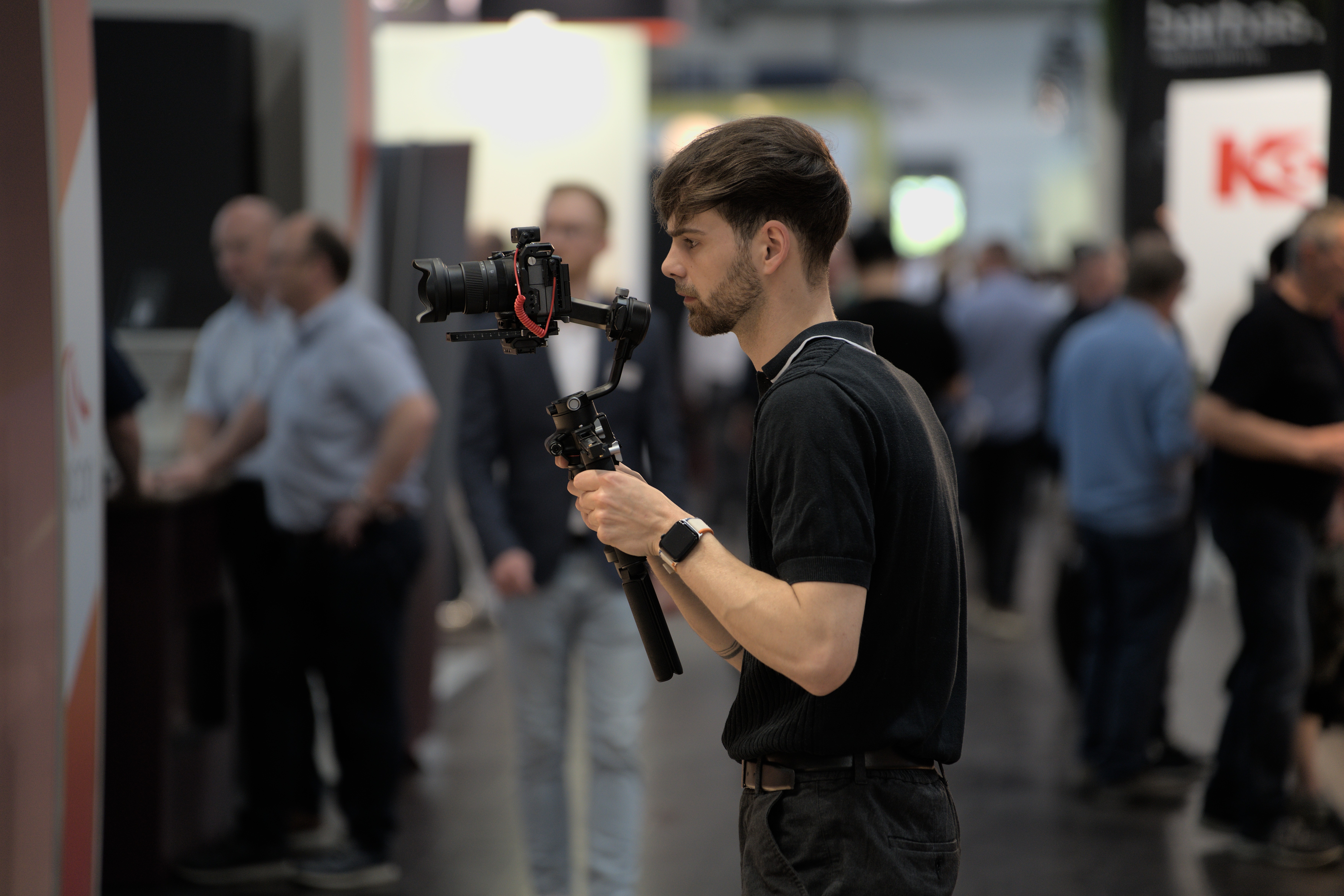videographf bei der Arbeit auf einer Messe zur Aftermovieproduktion