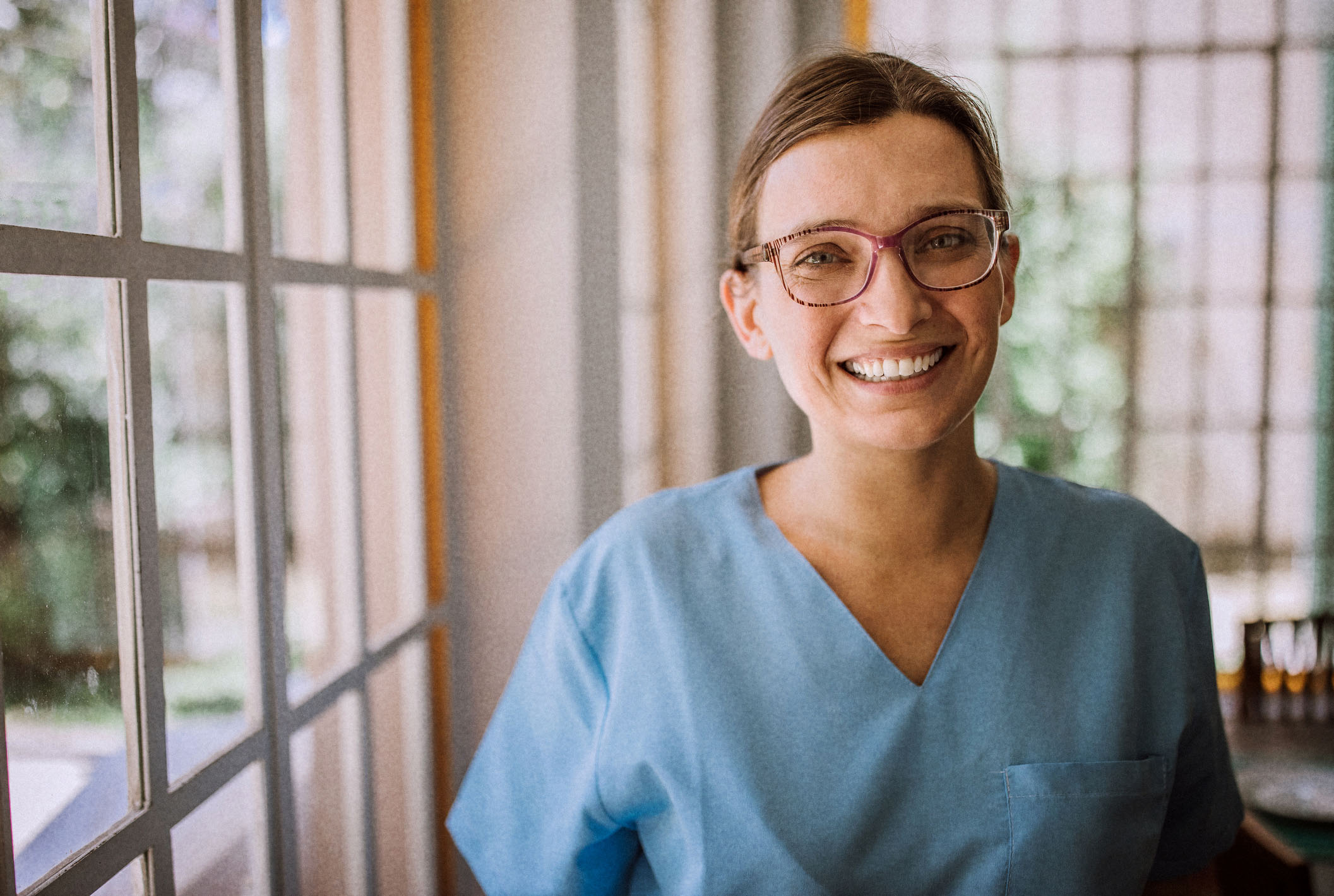 a woman wearing scrubs and smiling