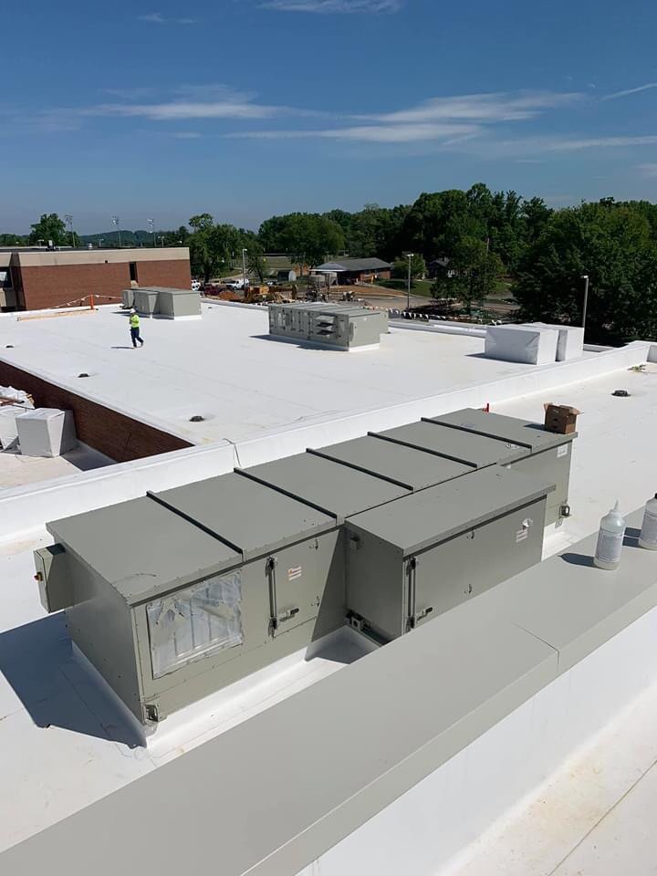 Man working on a brand new TPO 60 mil white roof. 