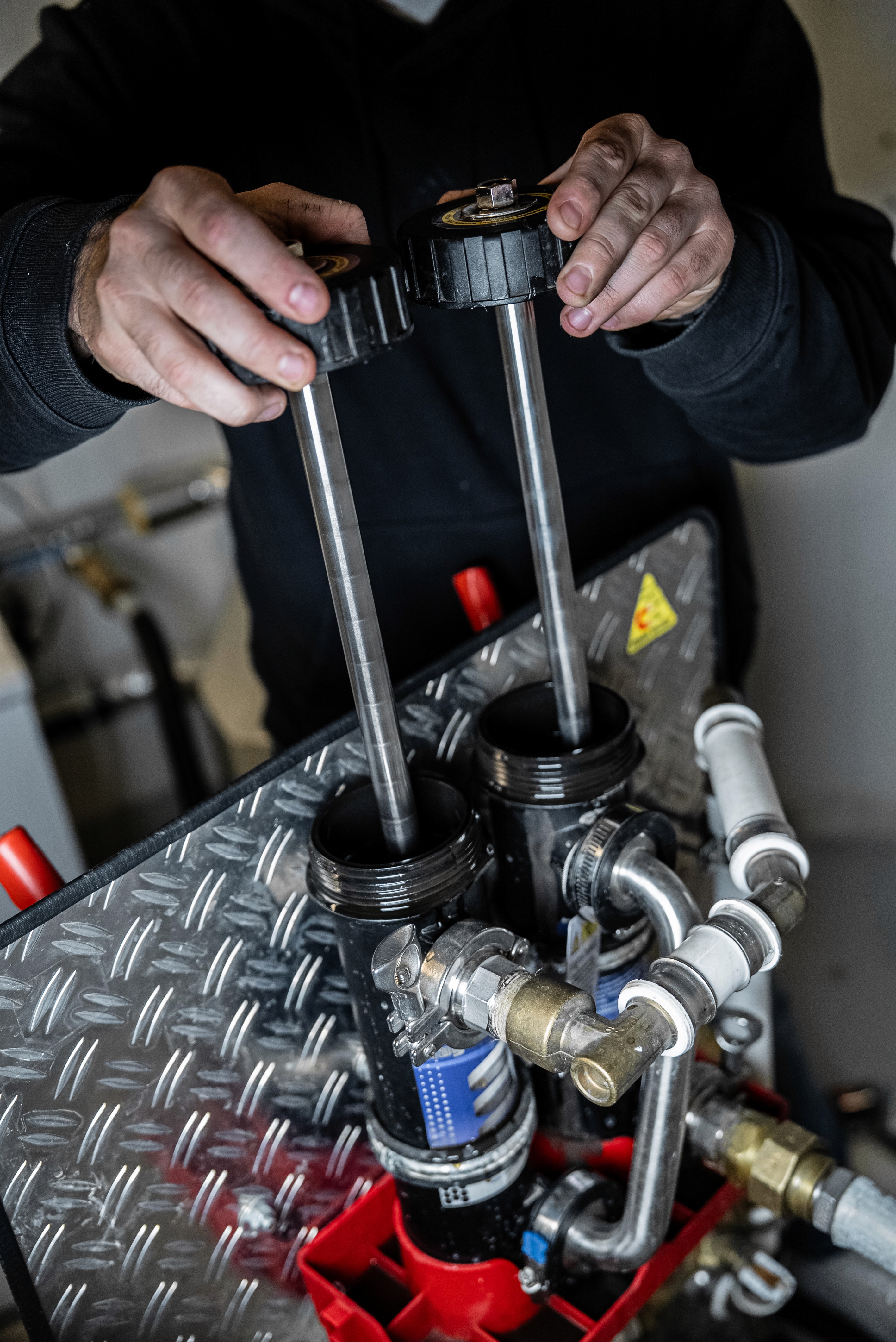 Three friends celebrating with gifts and a laptop; one sits on a pouf, the others on chairs.
