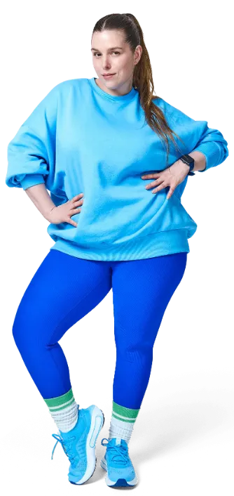 A person in a blue athletic outfit is lying on the ground, stretching out one arm and leg.