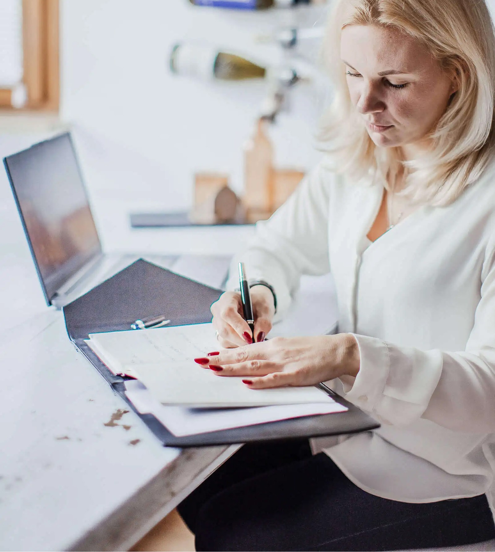 HR-Beraterin überprüft und dokumentiert Employer-Branding-Strategie an ihrem Schreibtisch