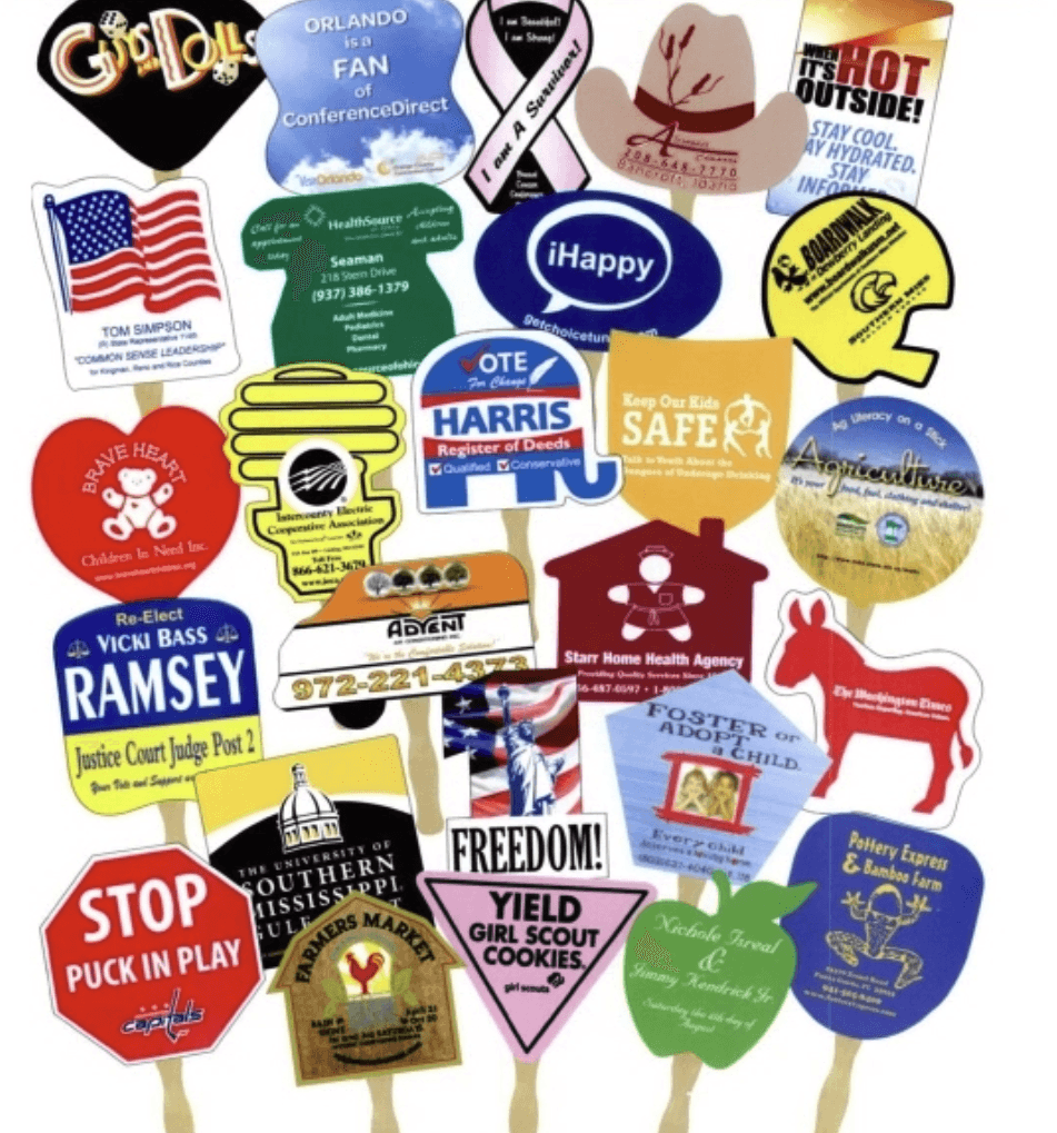 A multitude of sandwich hand fan examples all custom to the project in various shapes. Some of the shapes include donkeys, hearts, circles, flags, cowboy hats, and more.