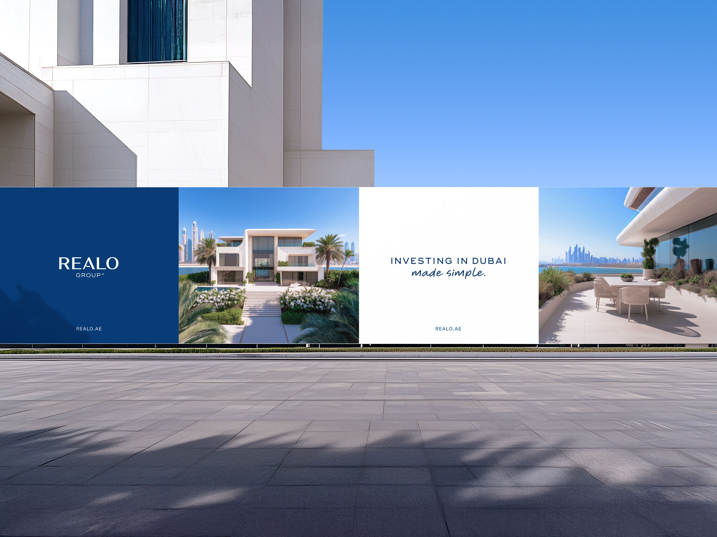 Outdoor construction hoarding featuring Realo Group branding, residential imagery, and the tagline “Investing in Dubai made simple.”