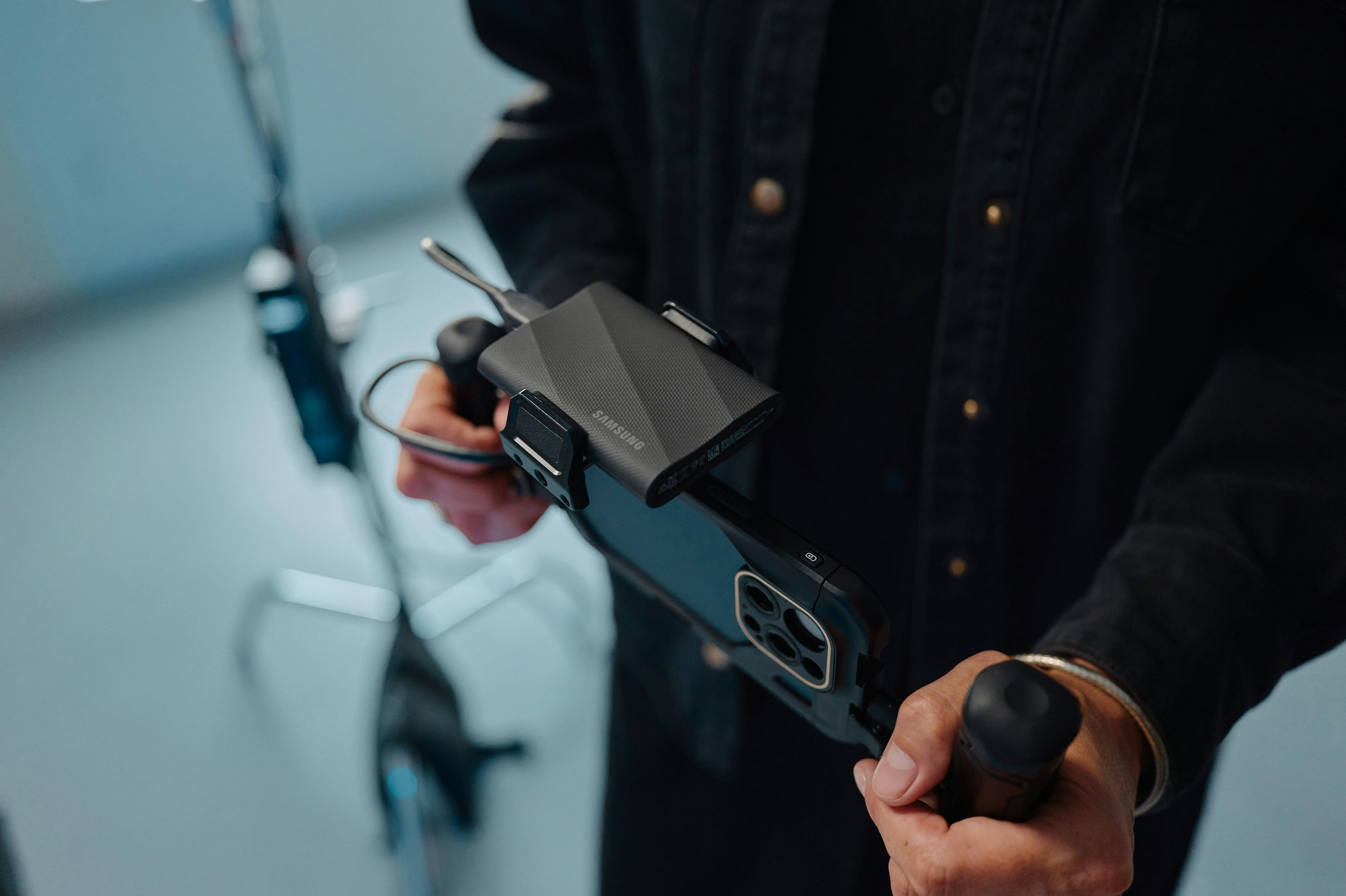 A picture of two hands holding a device attached to a phone.