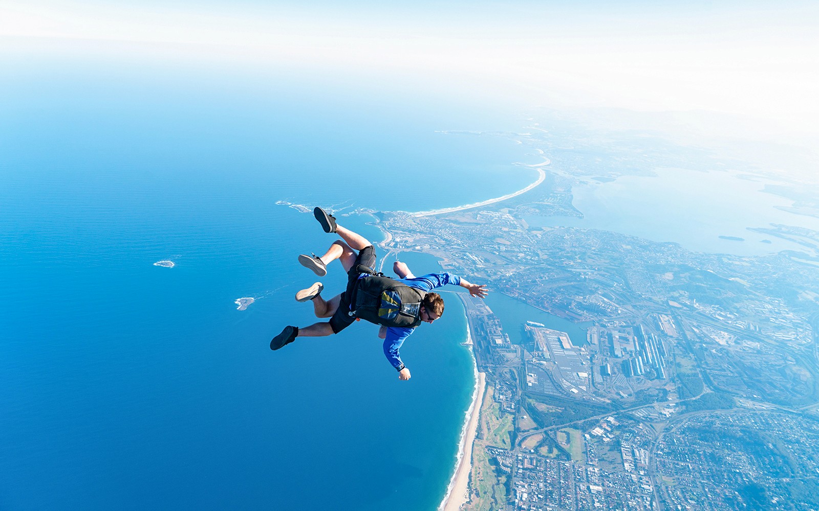 I paracadutisti in tandem si lanciano in caduta libera lungo la costa di Wollongong, vicino a Sydney.
