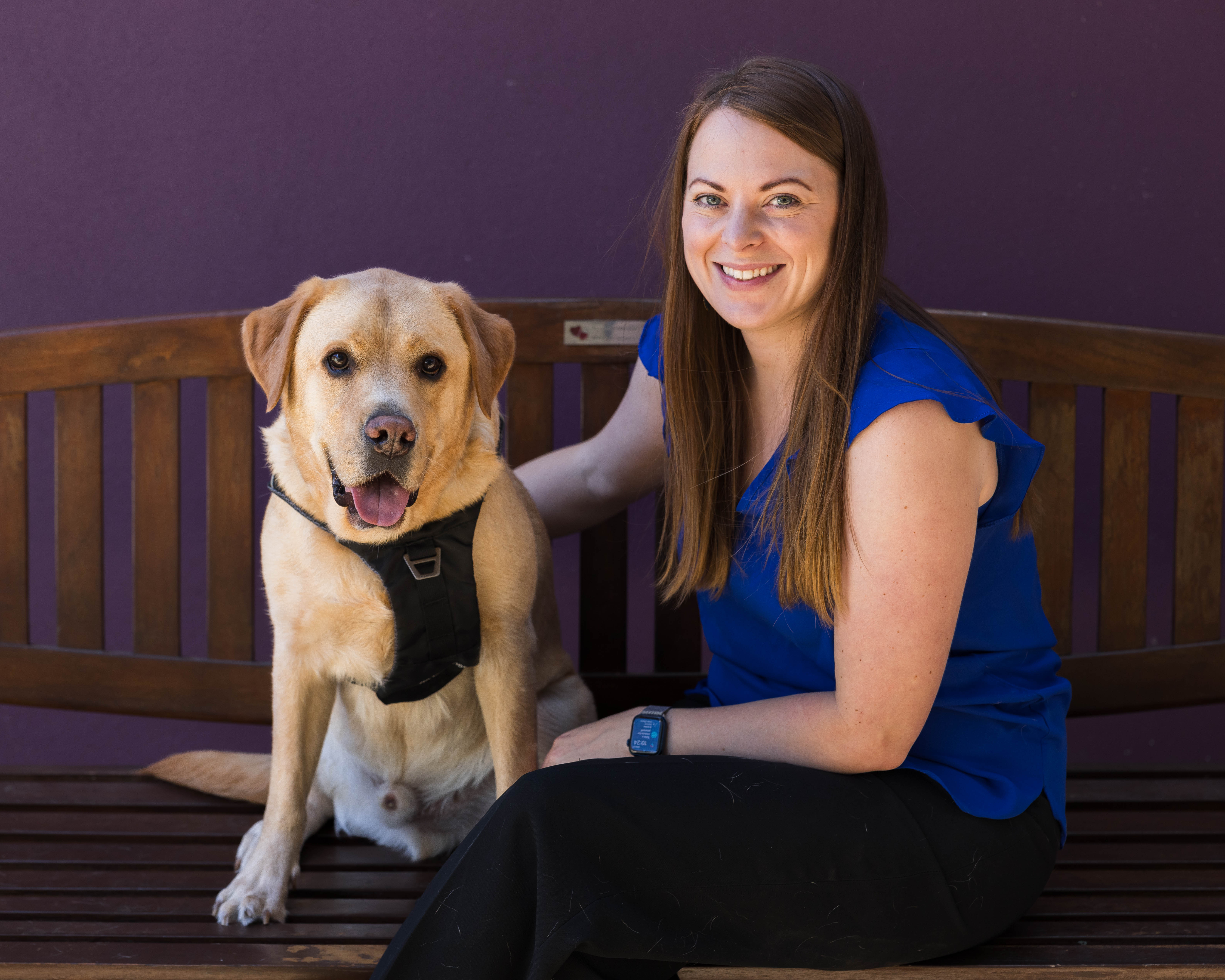 Woman sitting with her labrador on a bench