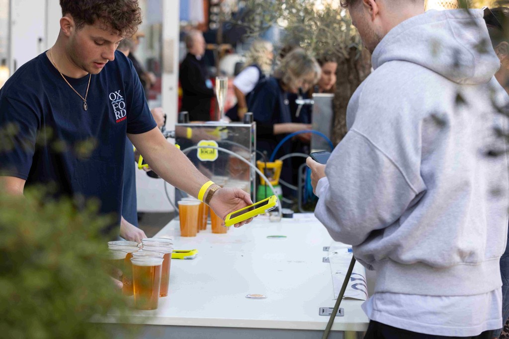 a customer buys beer with a Teya card machine at an open air bar