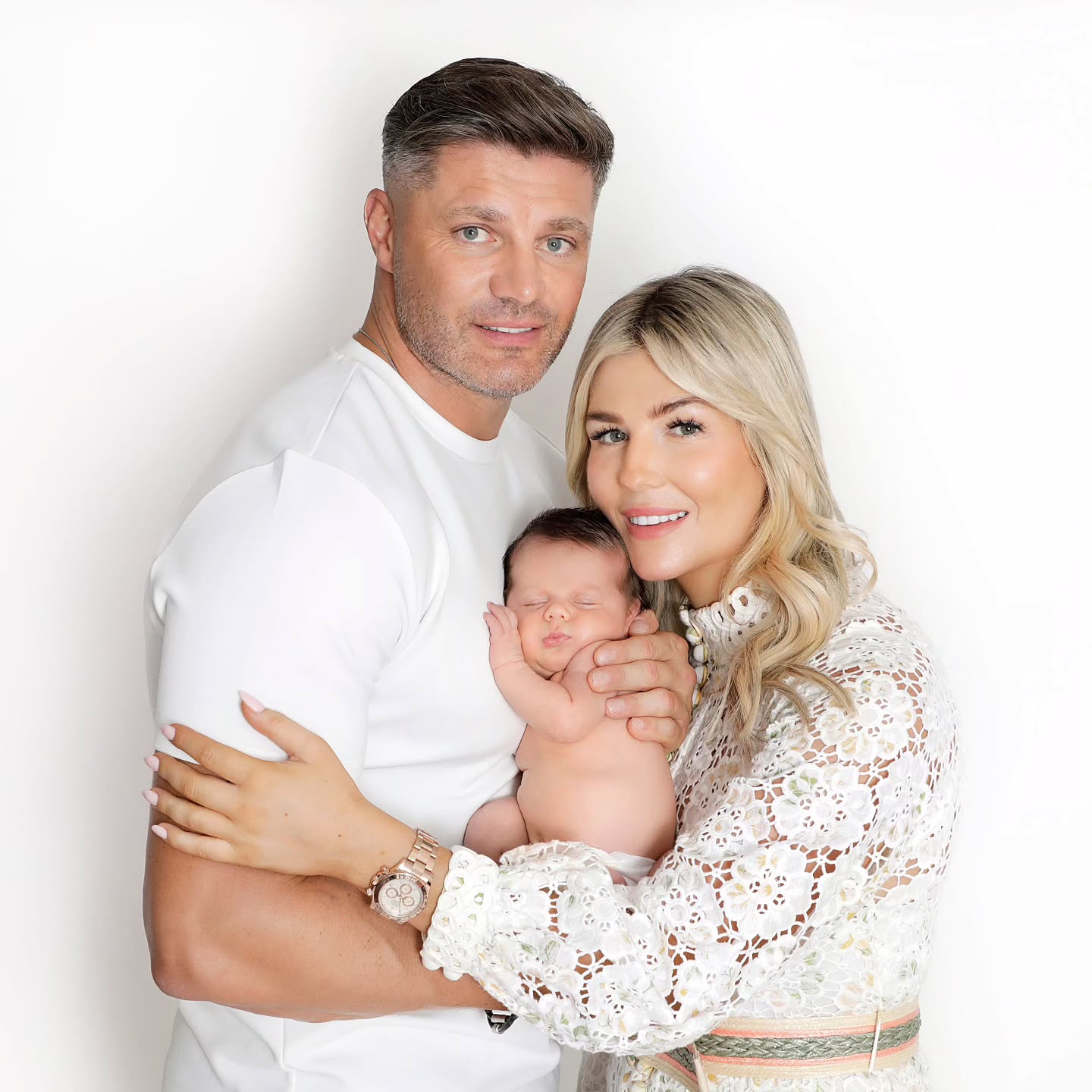 A happy family with a newborn in a professional and natural indoor family photoshoot with Mahvin Photography in Dubai, UAE.