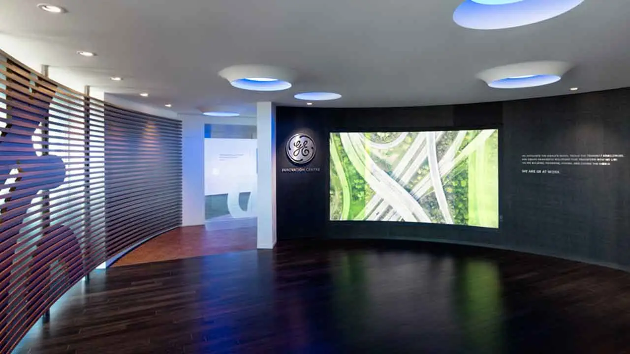 Curved digital screen showing aerial highway imagery in GE Calgary Innovation Centre, illustrating data-driven brand storytelling.
