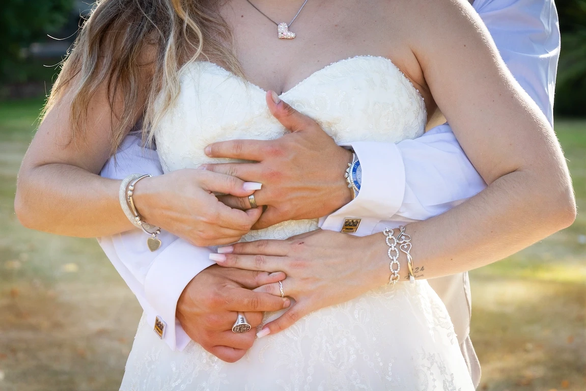 Close-up of Lauren and Ethan holding each other showing their wedding rings
