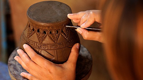 Hands making pottery