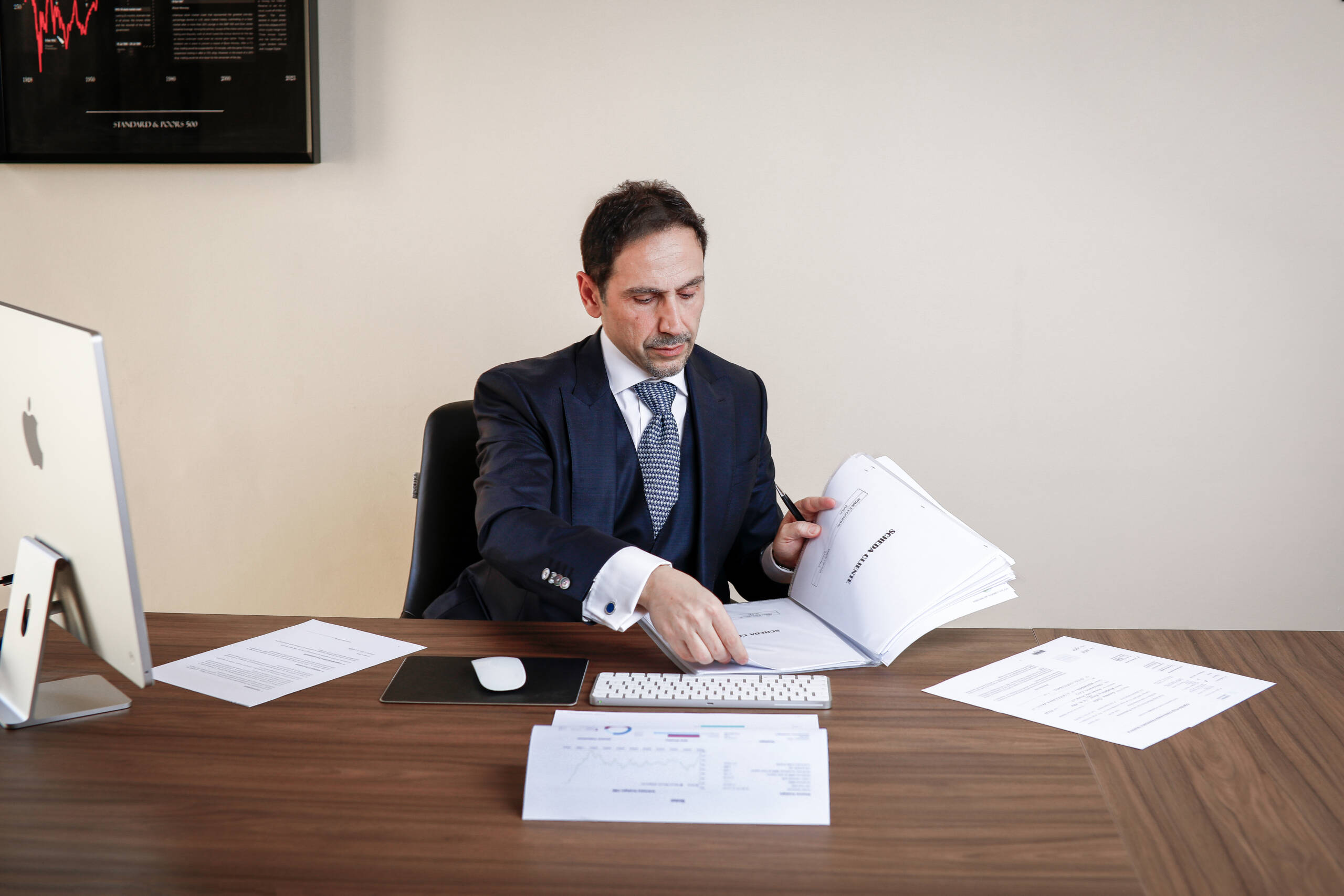 consulente azindale sfoglia carte sulla scrivania piena di impegni