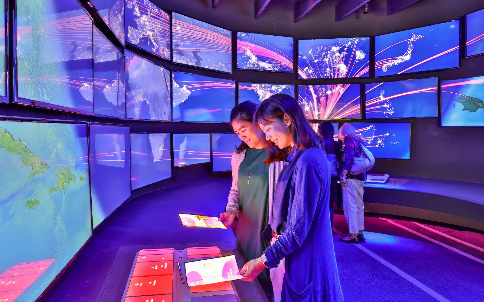 Two ladies observing flight paths at an exhibit at Changi Experience Studio.