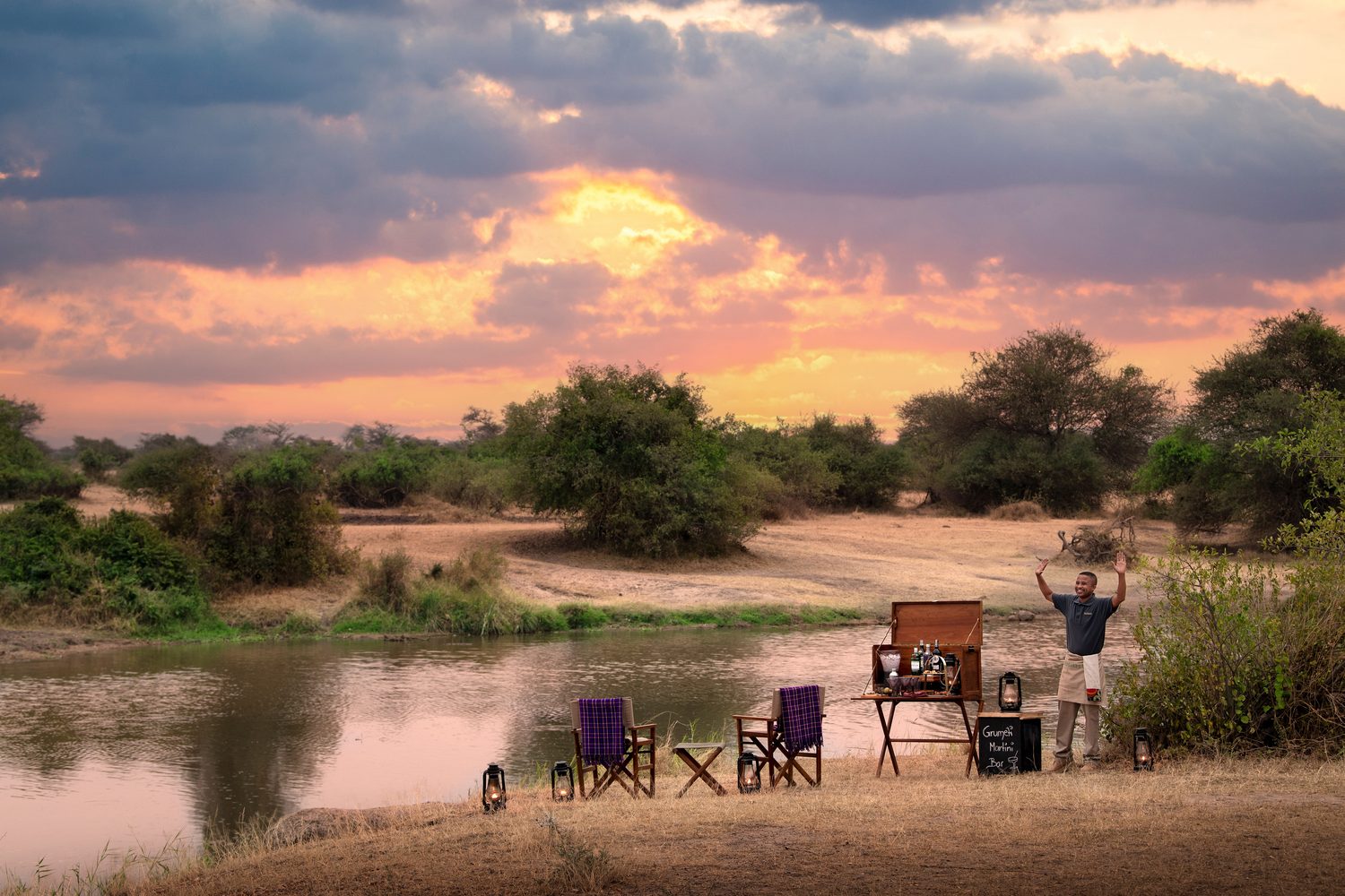 A guest celebrating a riverside coffee stop at sunrise