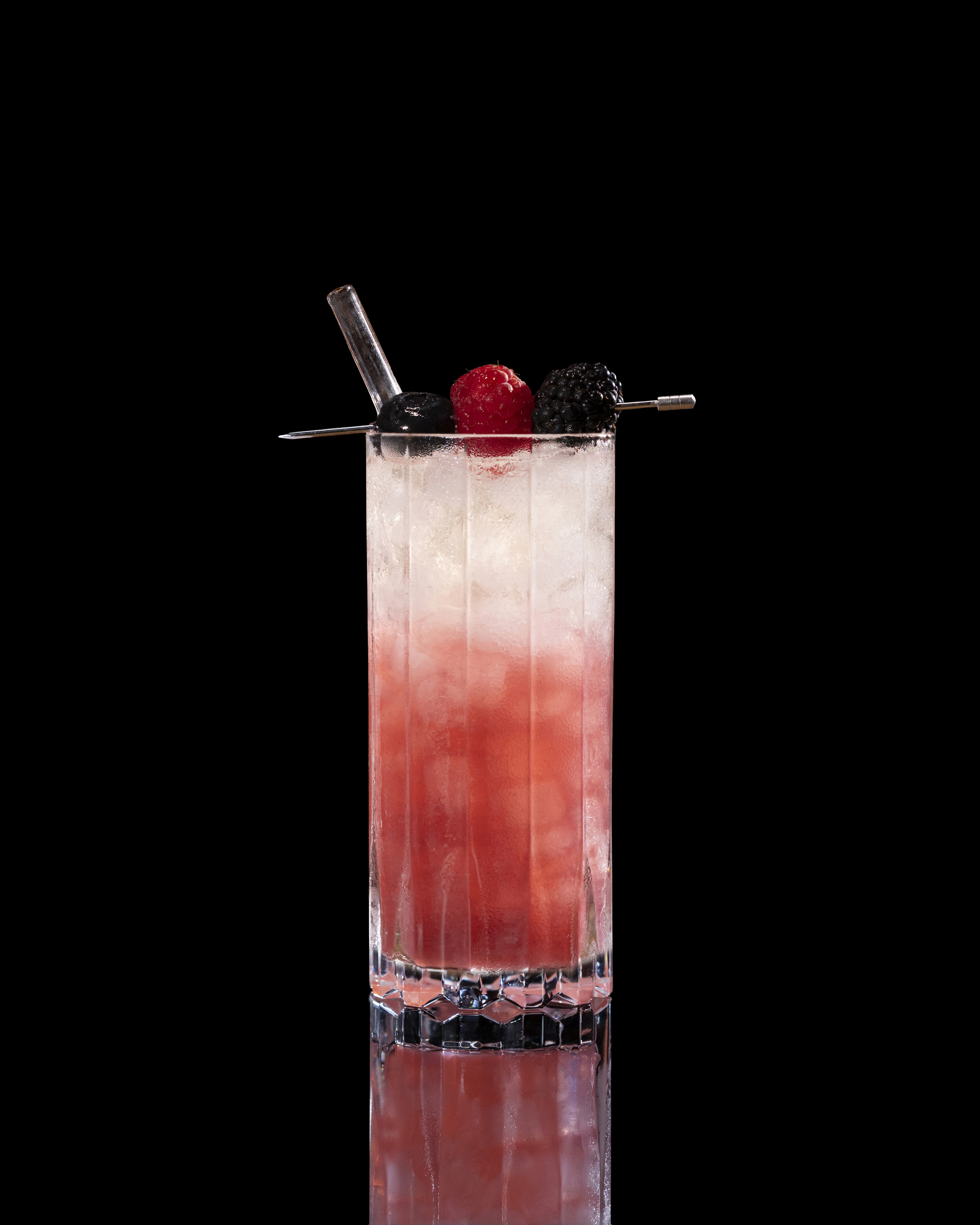 A closeup of a Almond Berry Spritz drink against a dark background.