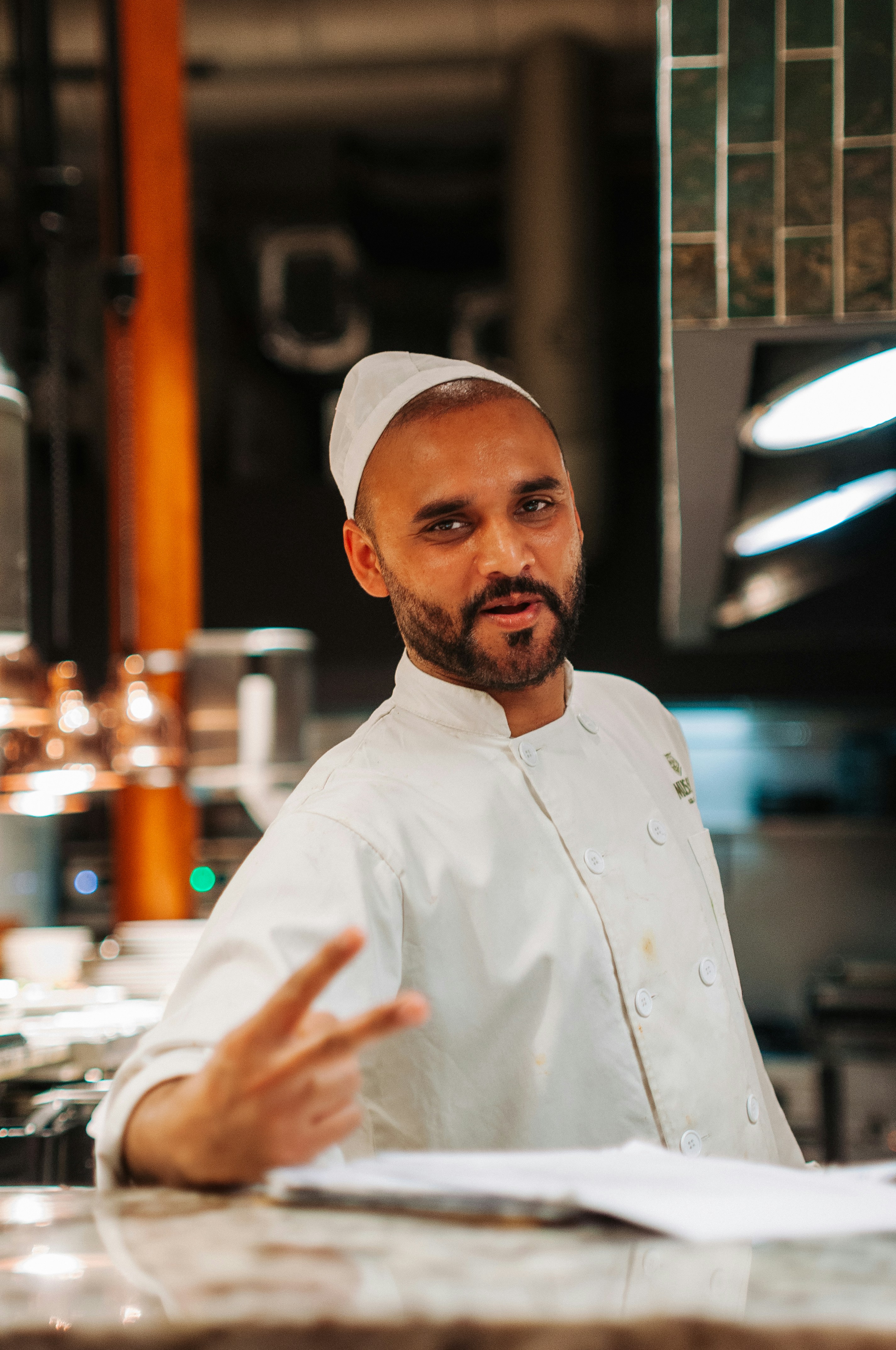 A man in a chef's outfit standing in front of a counter