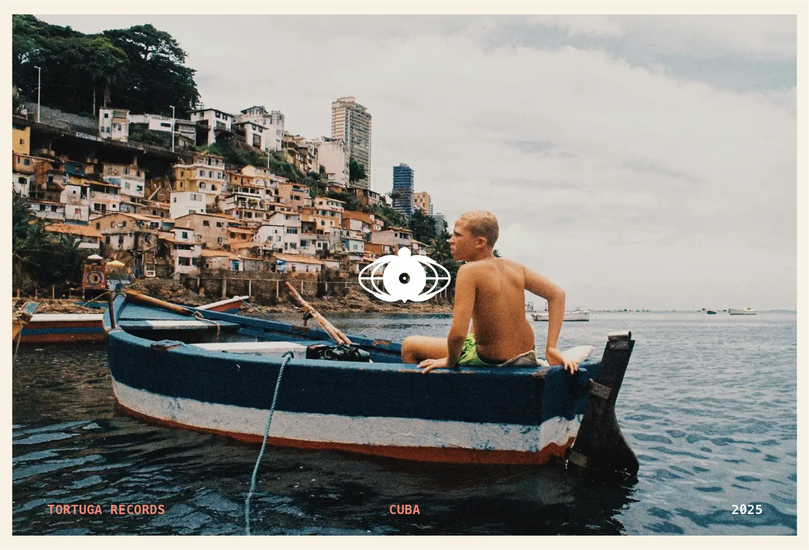 Postcard design with the Tortuga turtle icon over an analog photo of a boy in a small fishing boat off the Cuban coast.