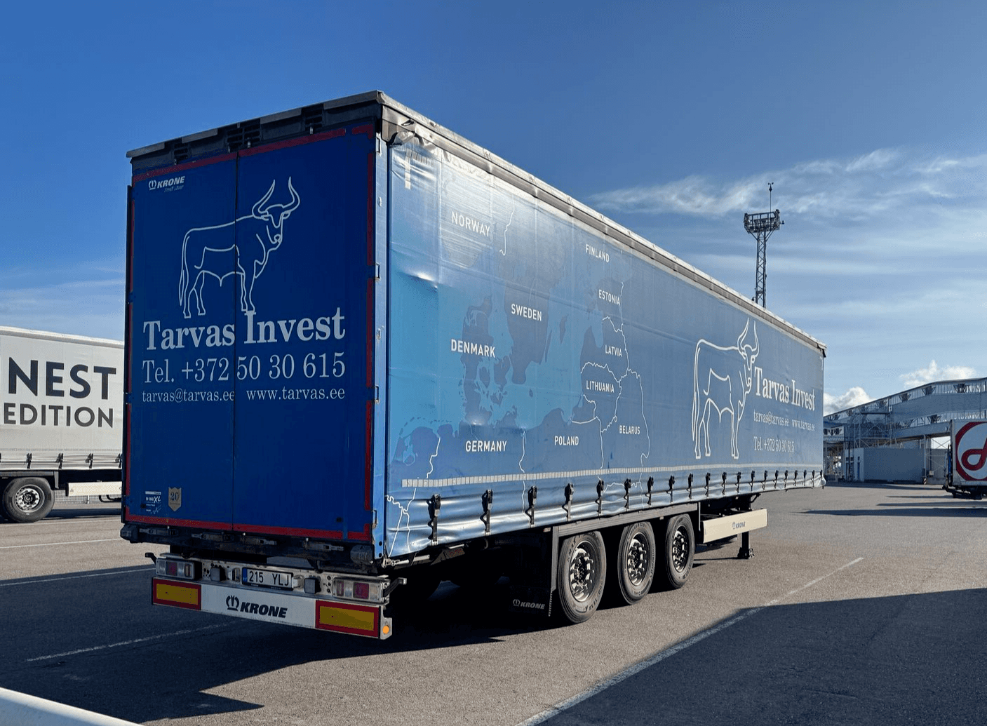 Blue Tarvas Invest curtainsider trailer parked at a port terminal