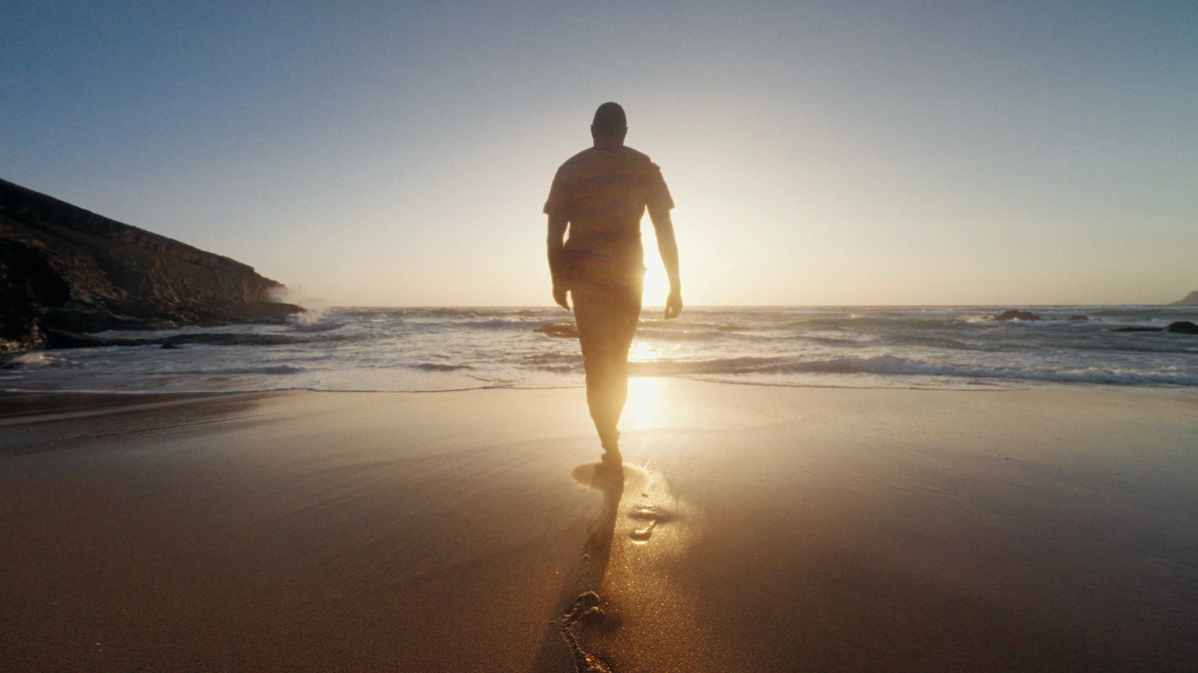 a man walks into the sea in a frame from Life among Worlds