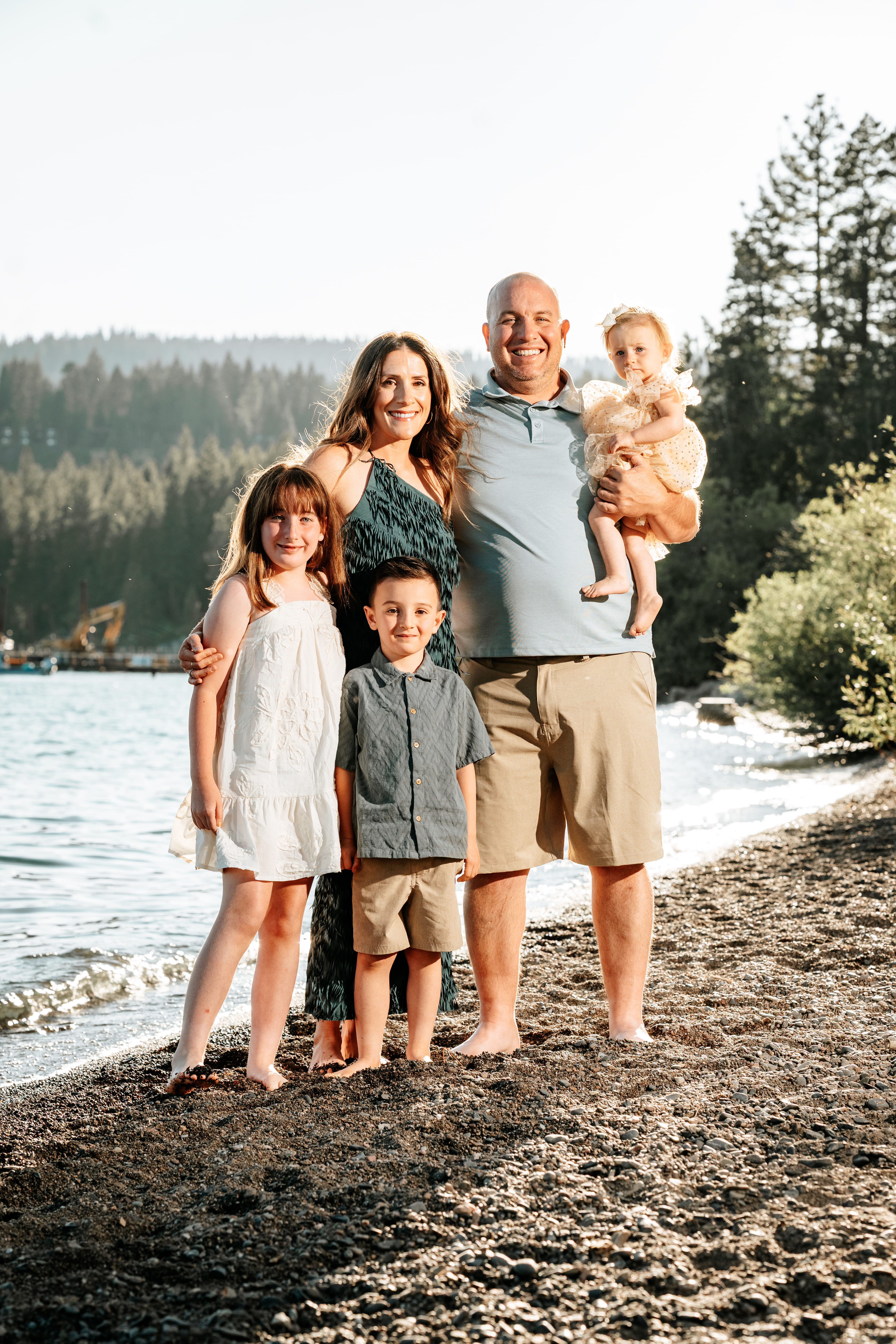 A bride and groom share a kiss surrounded by a joyful bridal party.
