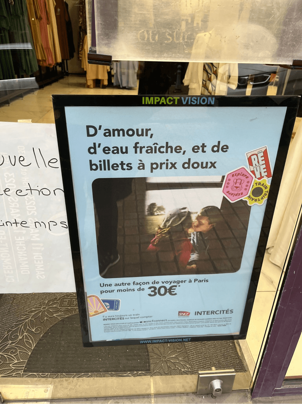 Porte affiche Impact vision sur une vitrine de magasin