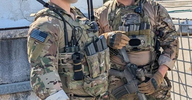 Best plate carriers 2026 — two soldiers in MultiCam wearing loaded plate carriers with magazine pouches
