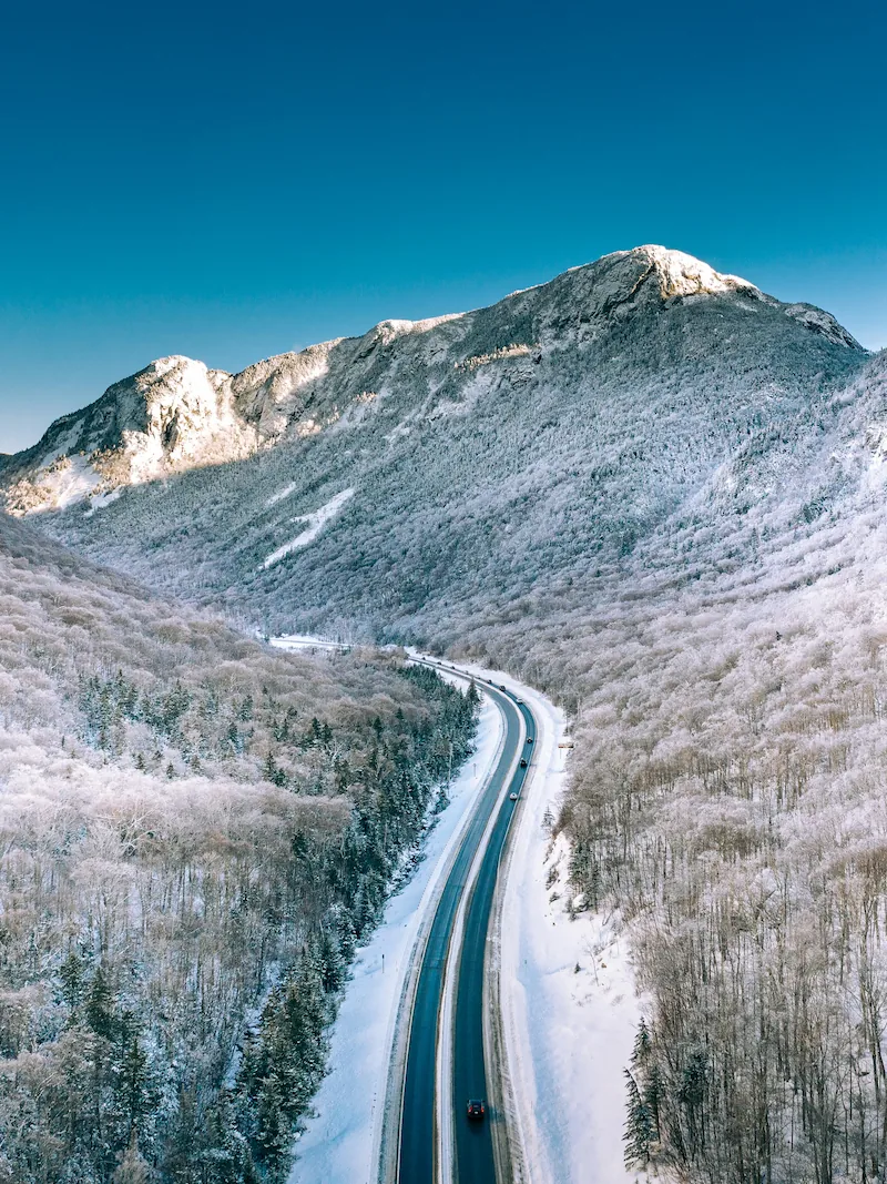 Snow-covered rural road curving through mountains