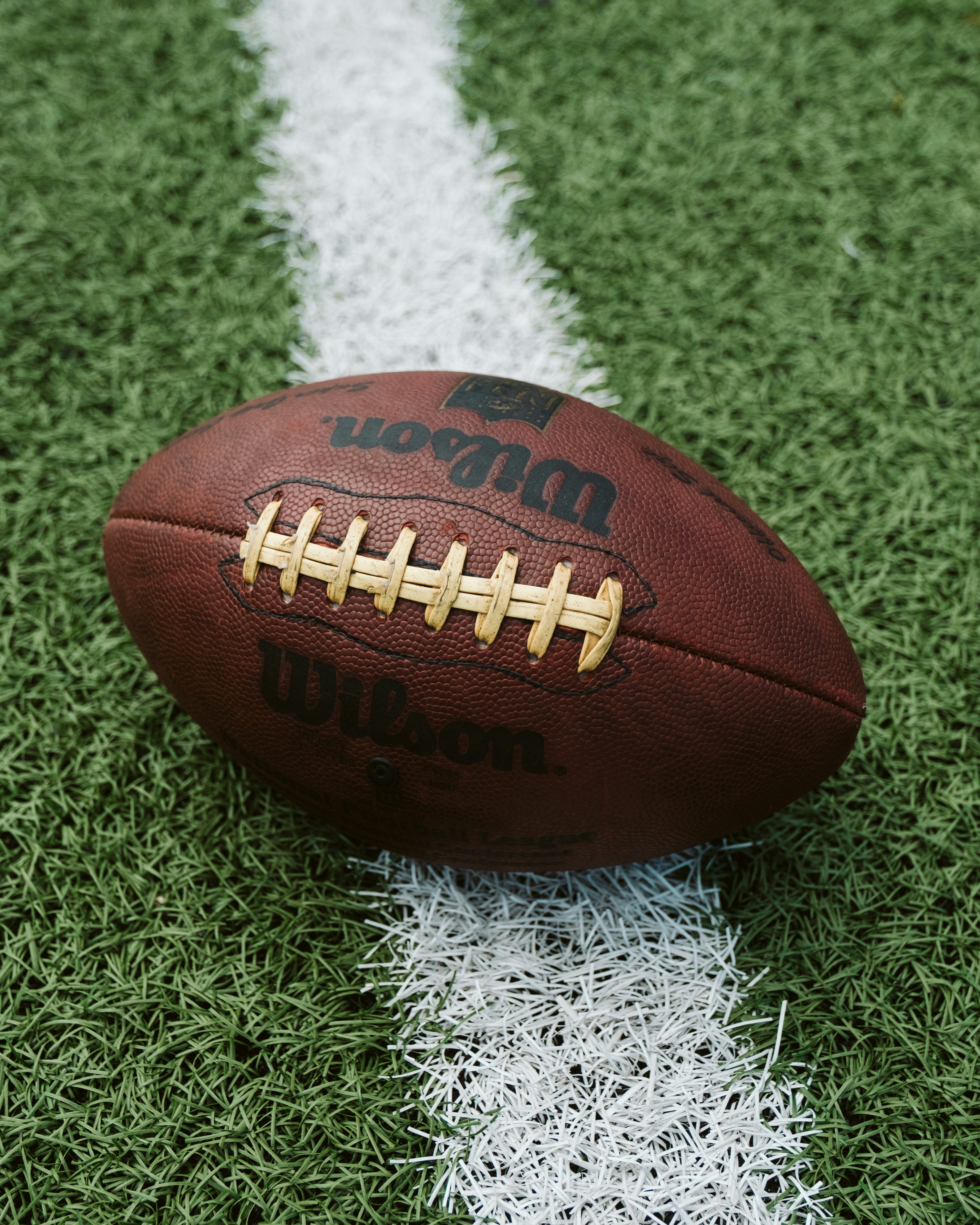 Close-up of a Wilson American football ball on green turf