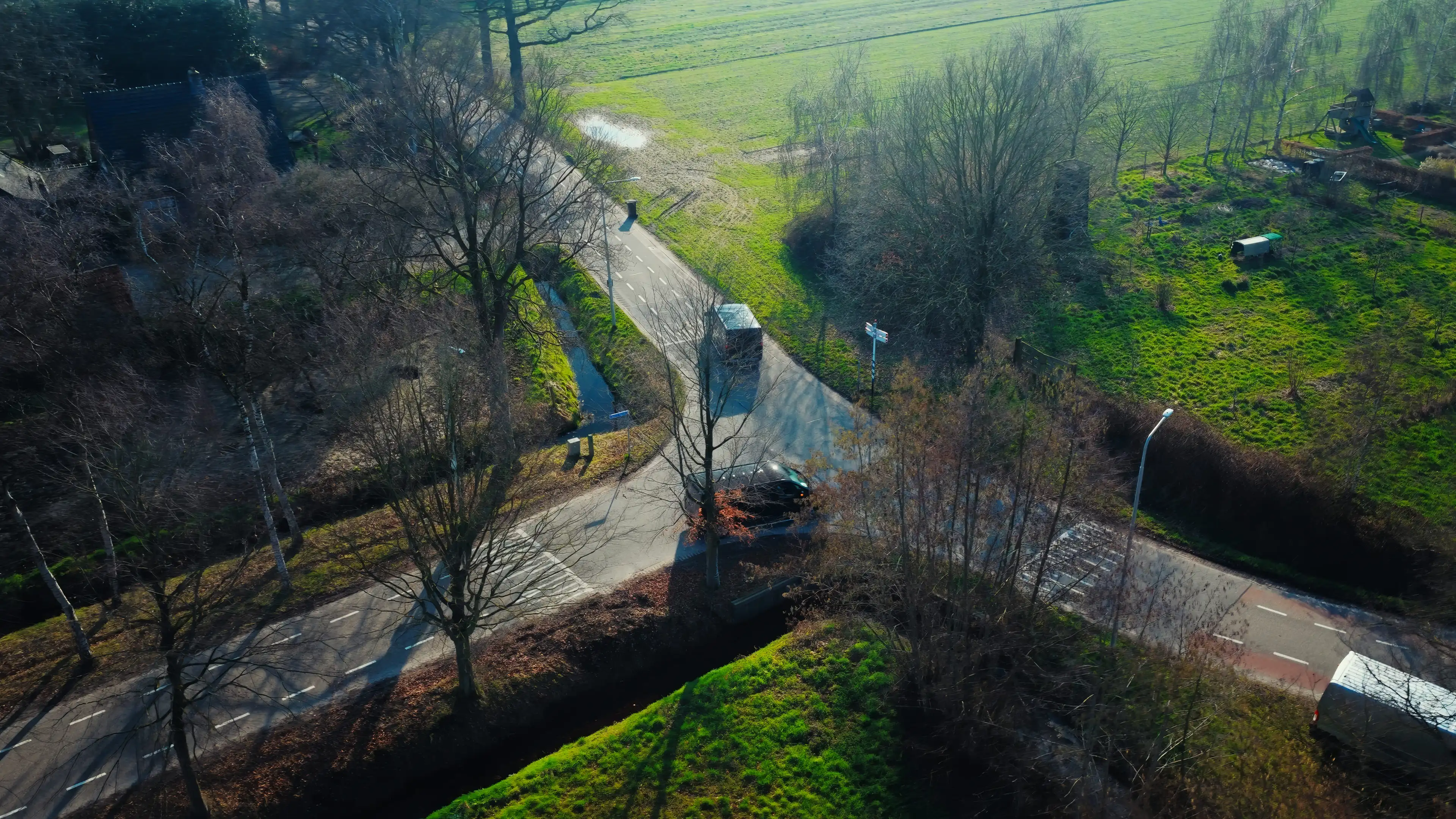 Dronebeeld van een bestelbus op een kruising in het buitengebied
