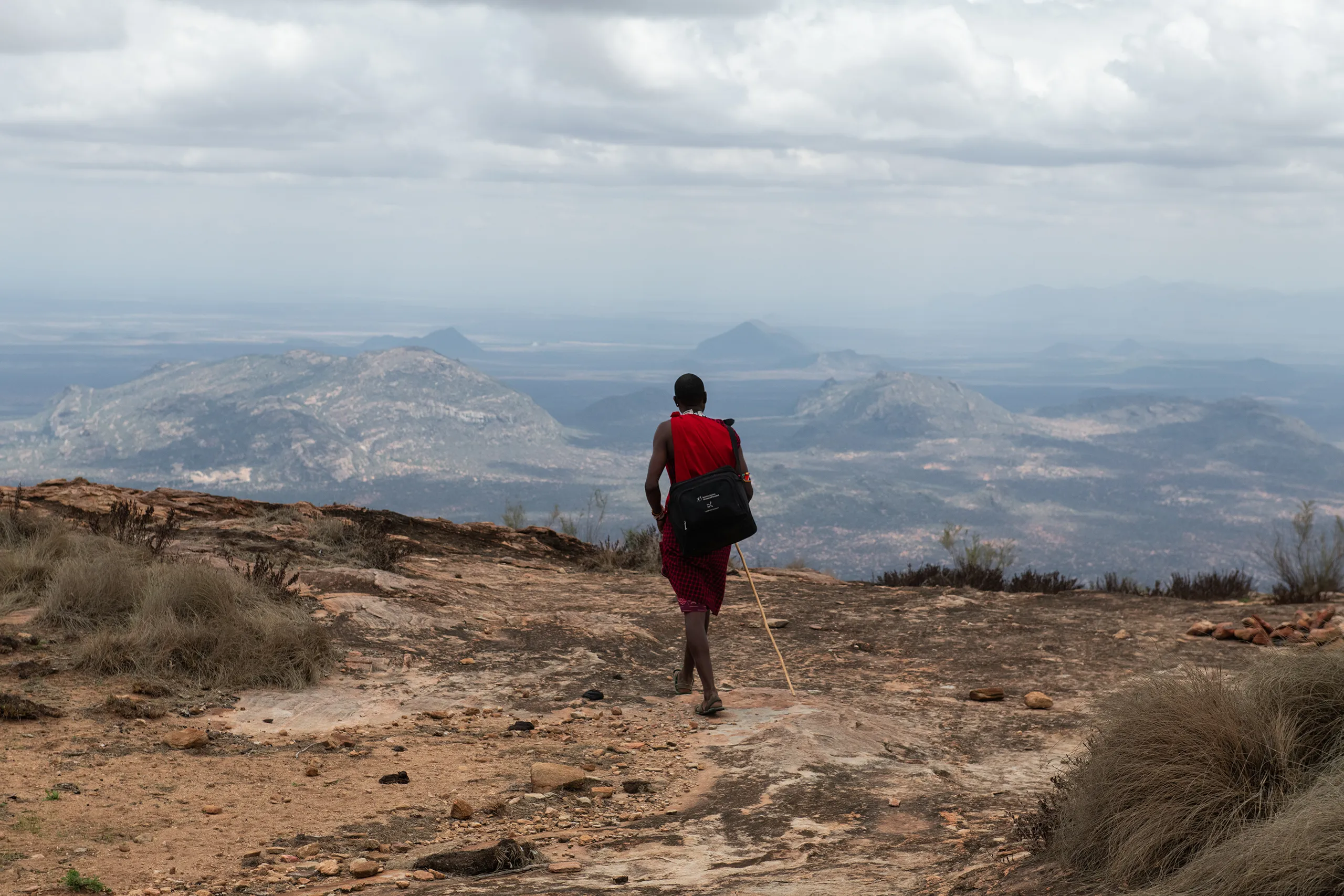 A scenic shot of a person hiking along a narrow mountain ridge overlooking a deep valley.