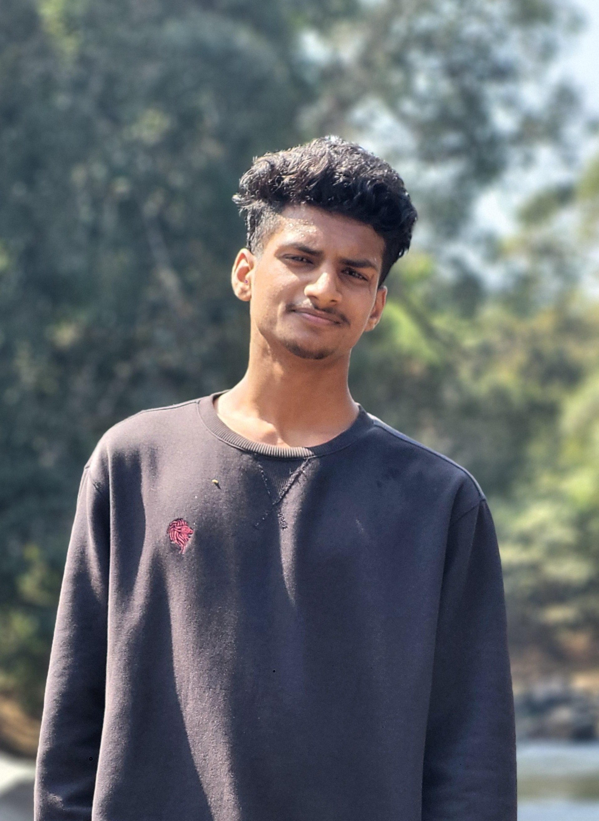 a man wearing glasses and a blazer with a lighting that casts a soft shadow on the wall behind him